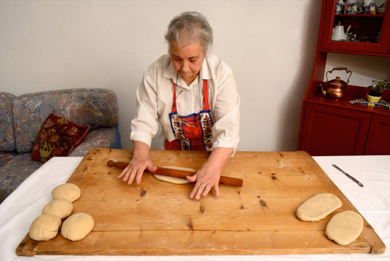 Older woman rolling dough on board