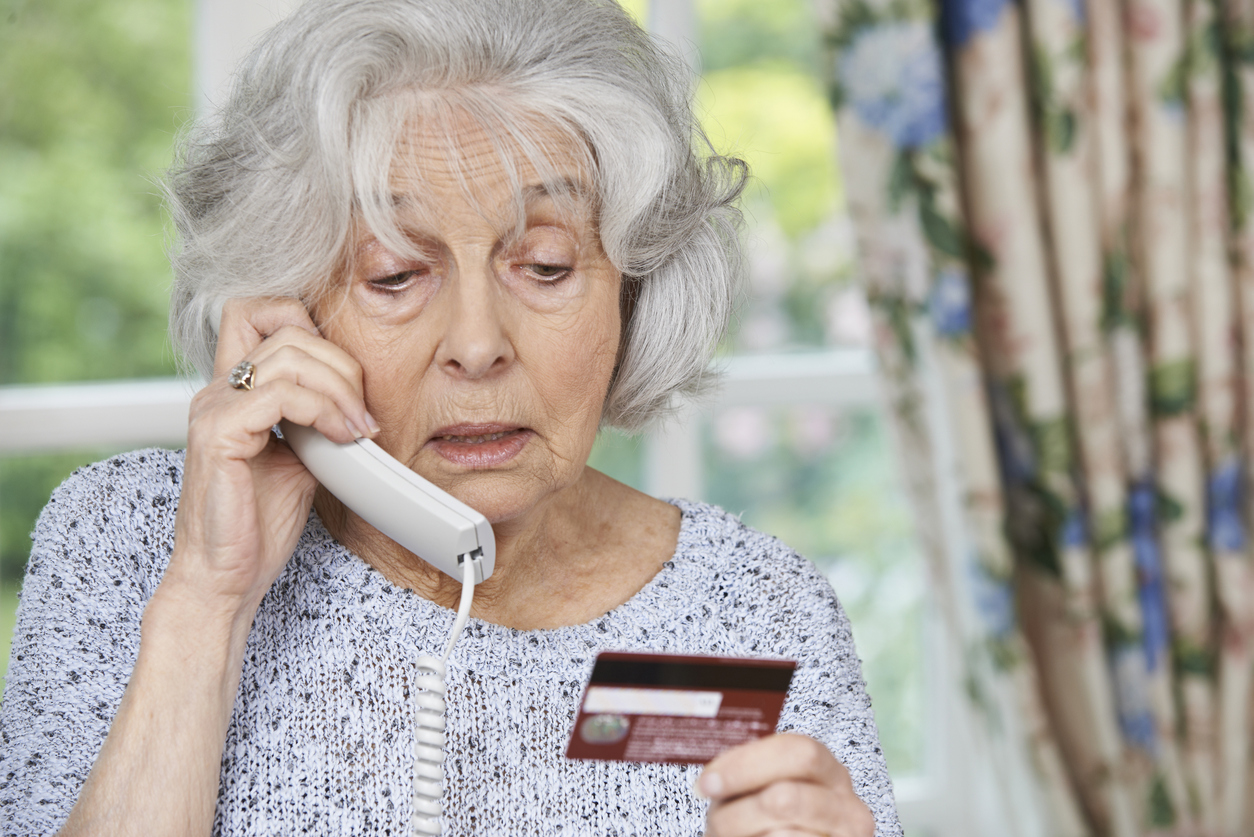 Senior Woman Giving Credit Card Details On The Phone