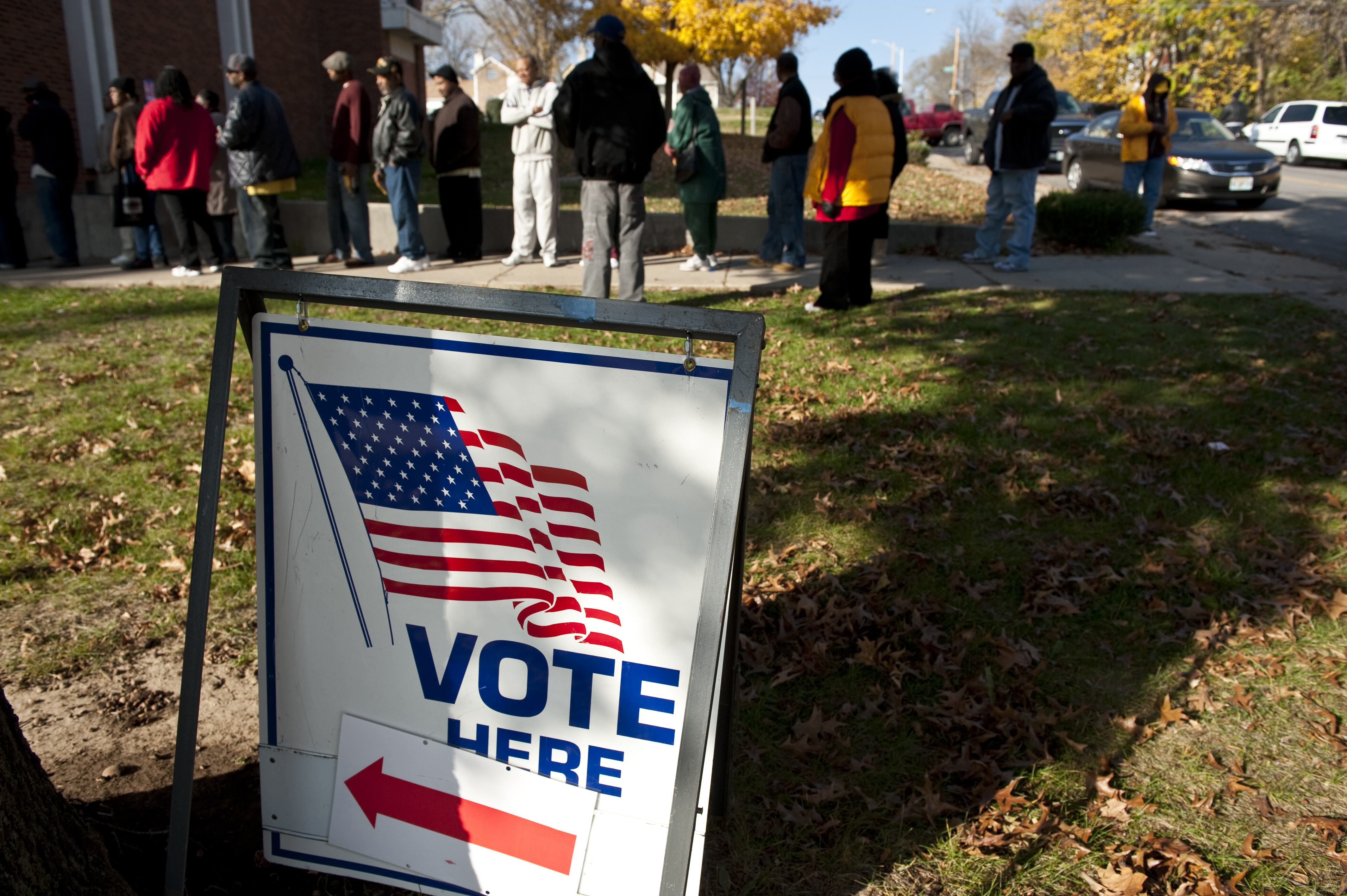 Voters stand in line outside of a polling location.