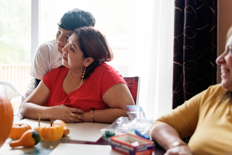 Tender moment for Latin American family carving pumpkins for Halloween