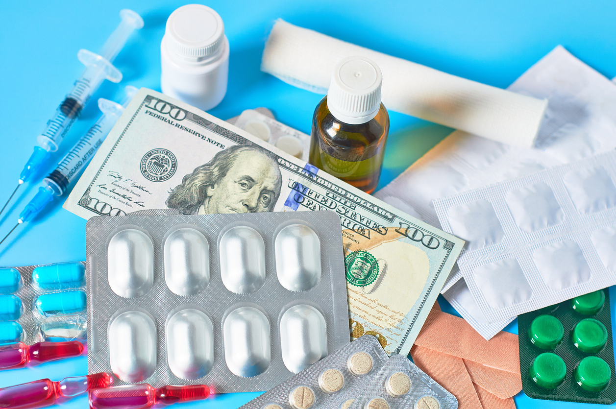 Different medicaments and money on blue background. Medical concept. Doctor salary. Corruption in healthcare.  Purchase of drugs. Health insurance. Virus vaccine manufacturing cost