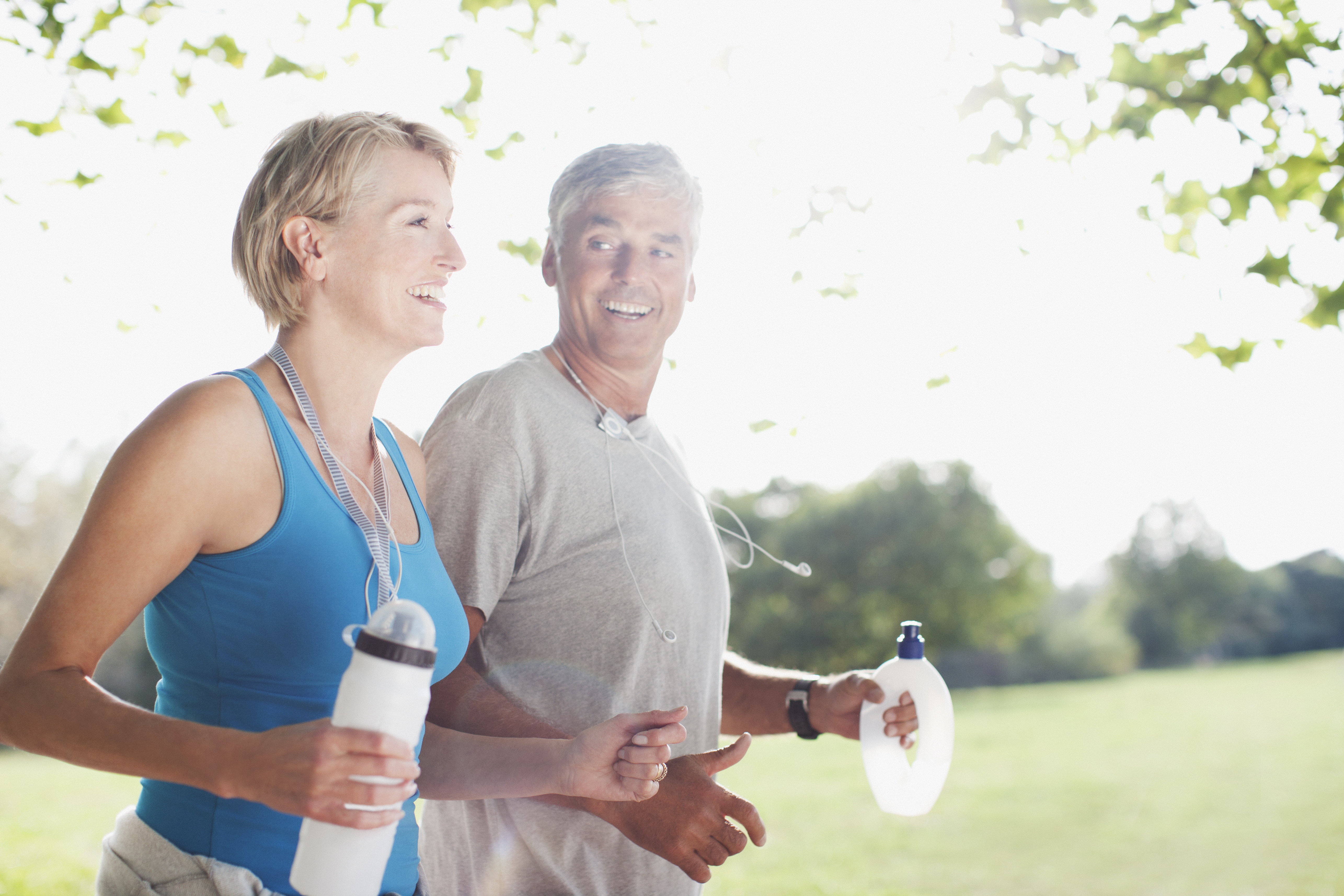 Couple jogging together with water bottles