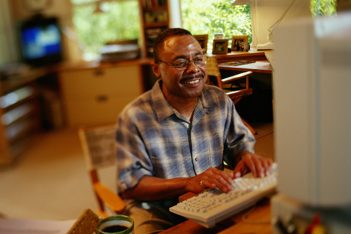 MAN ON COMPUTER AT HOME, AFRICAN AMERICAN