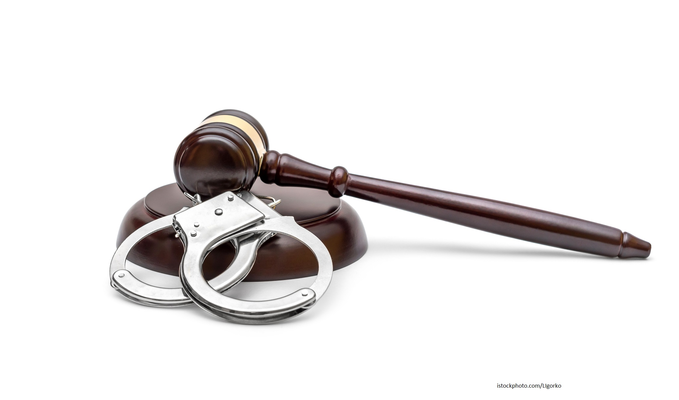 Handcuffs with judge's gavel on white background. Law concept.