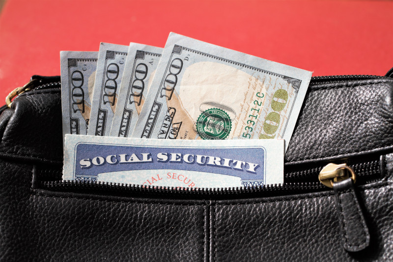 Social security card and hundred dollar bills in handbag pocket