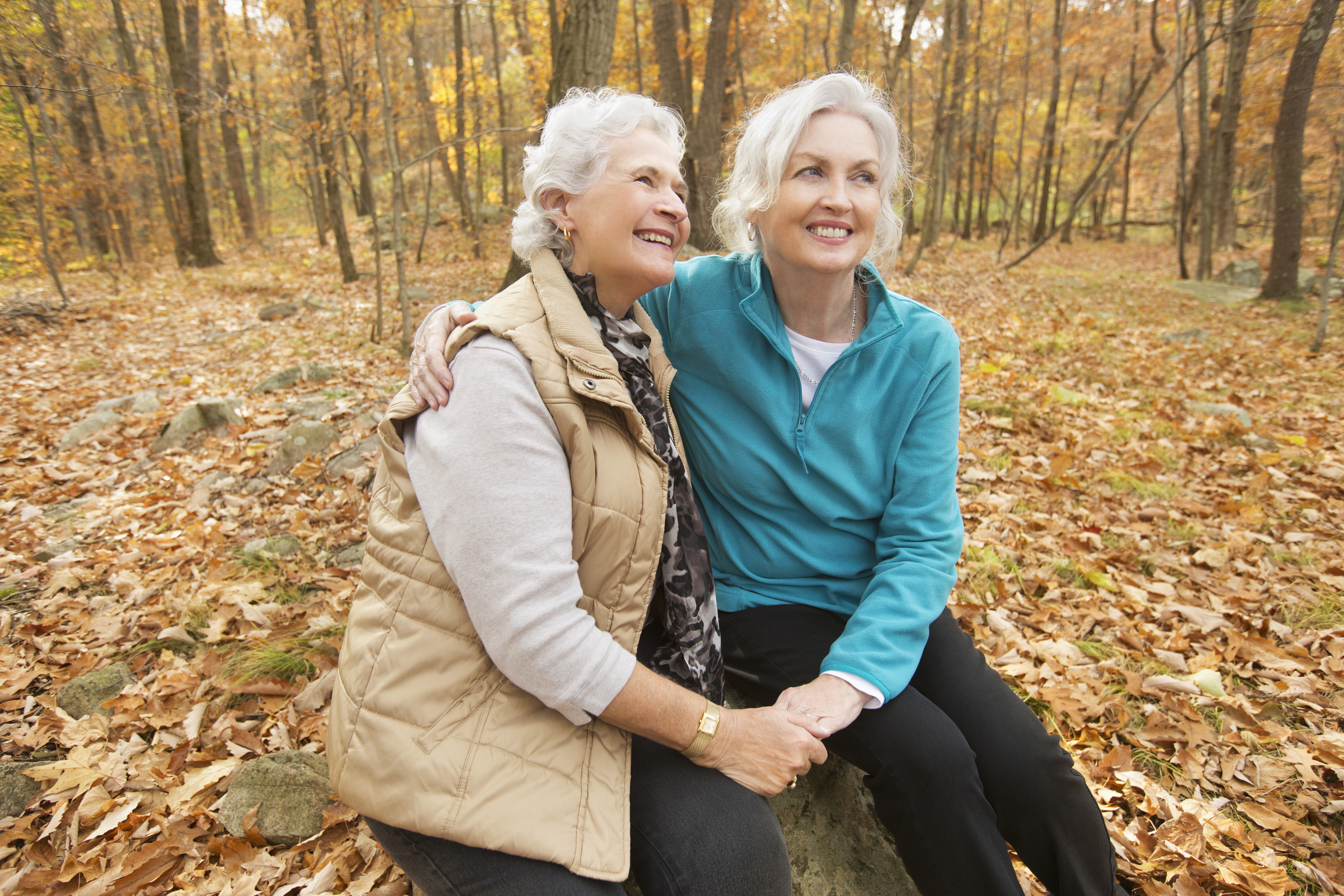 Caucasian women hugging outdoors in autumn