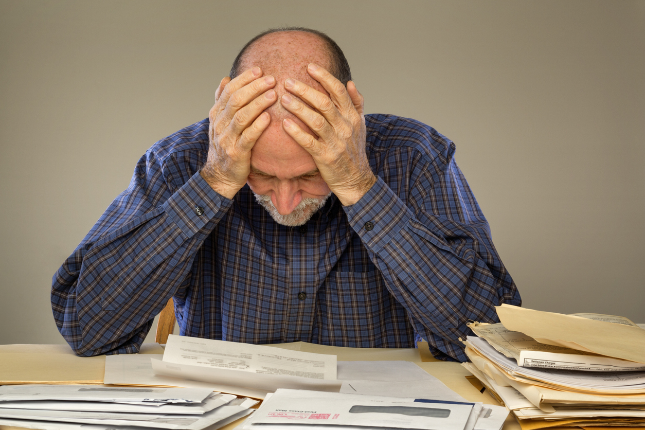 Depressed Senior Adult Man With Stacks of Papers and Envelopes