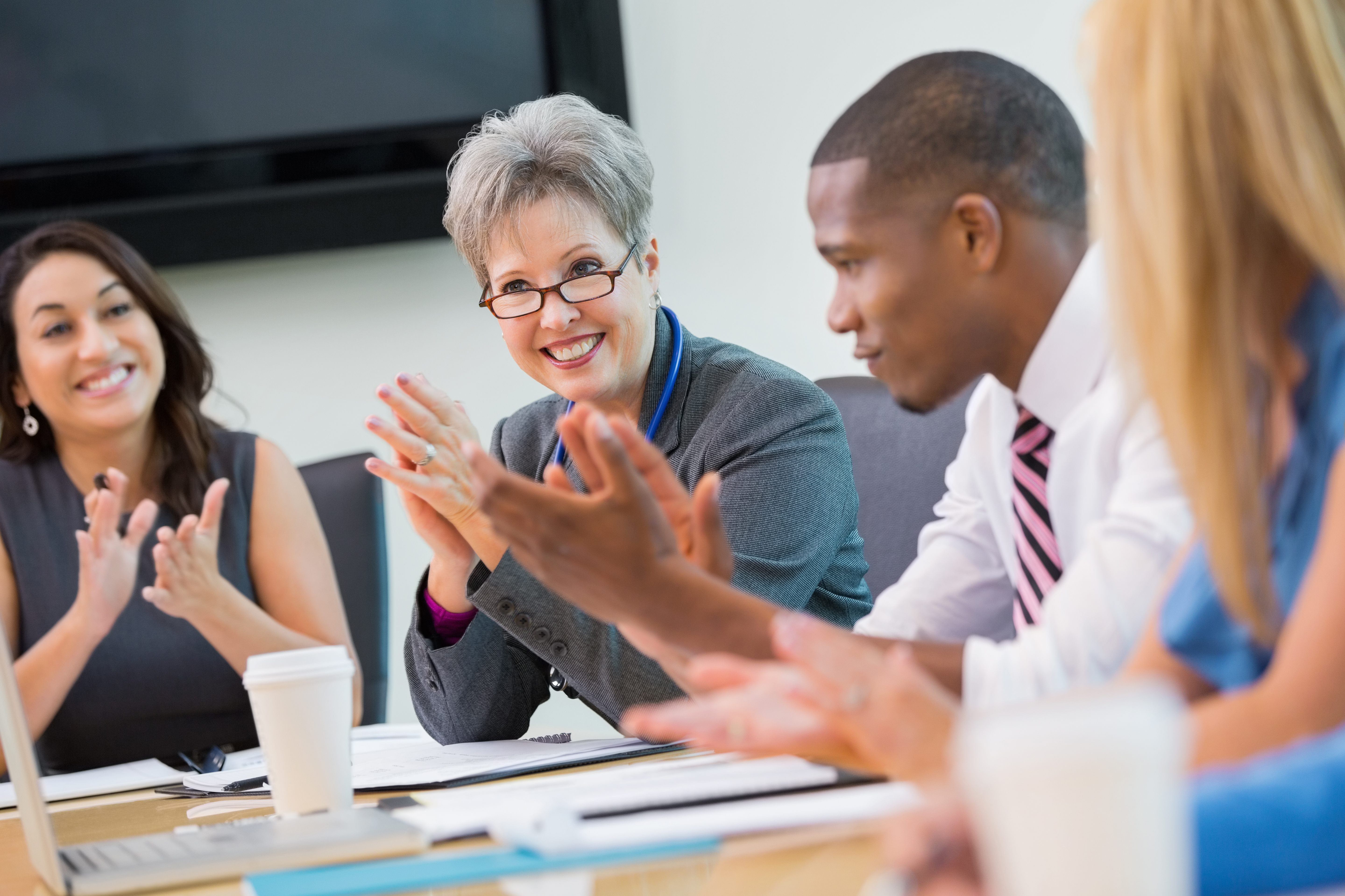 Diverse business team applauding during staff meeting