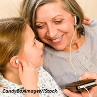 Grandmother and young girl listen music together