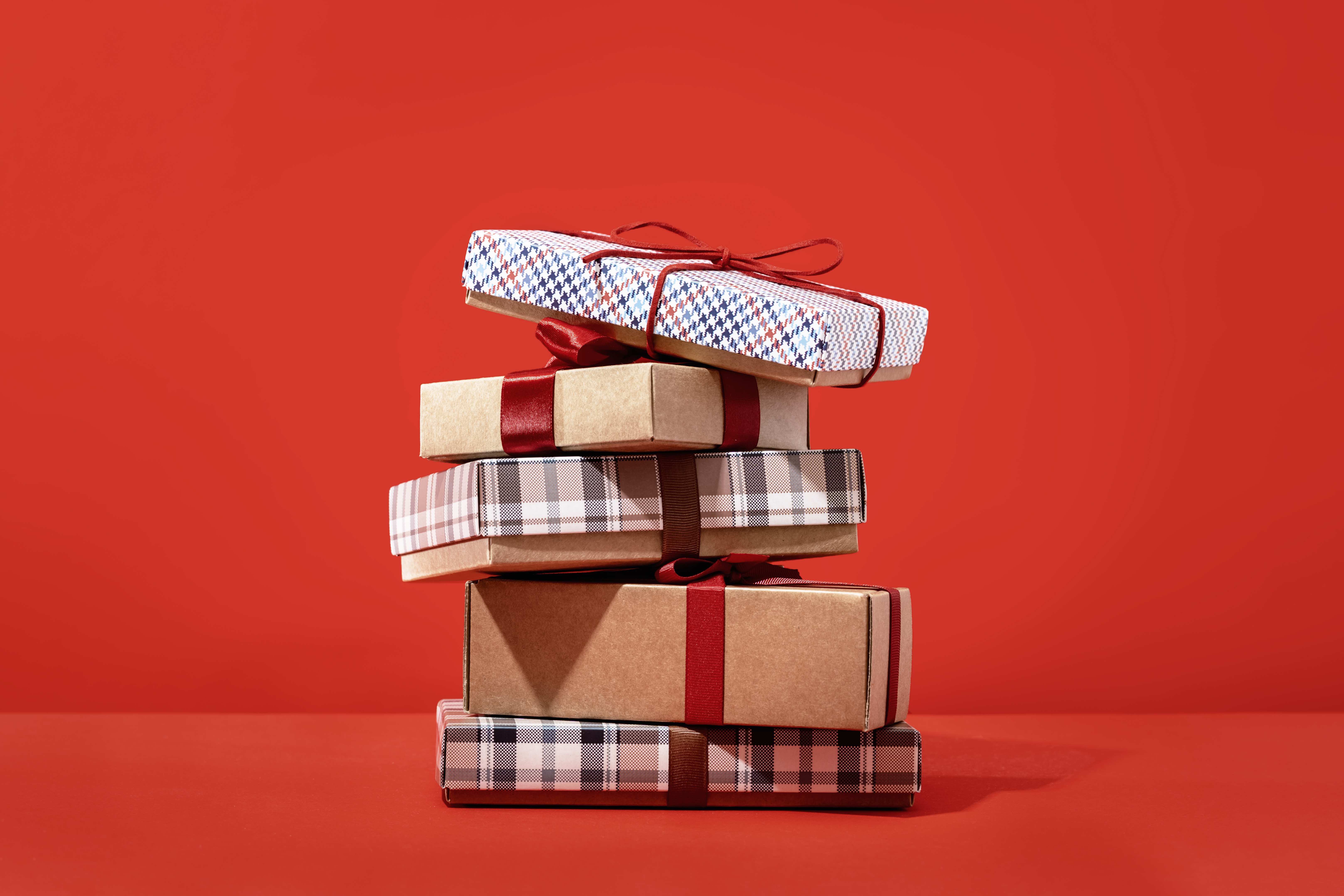 Several brown gift boxes in a pile on red