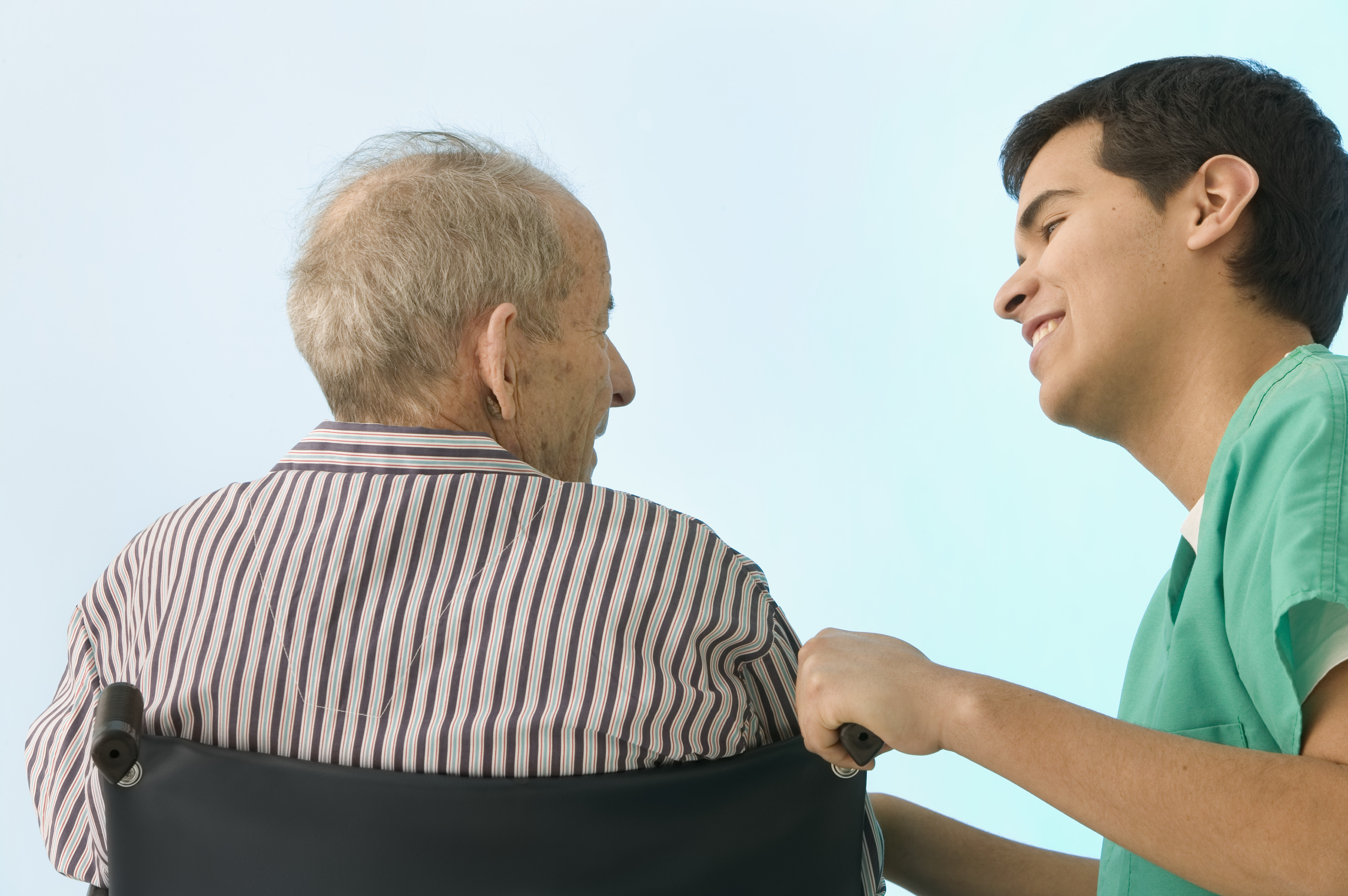 Male nurse helping senior man in a wheelchair