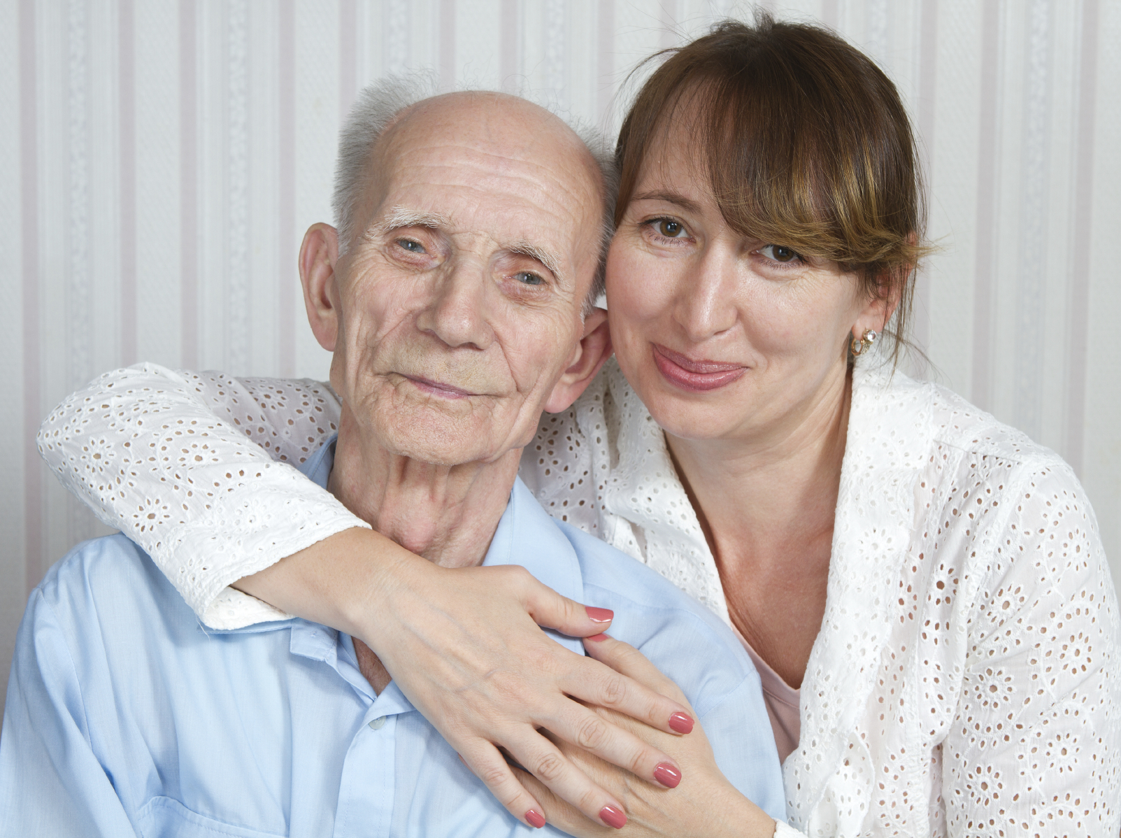 Senior man, woman with their caregiver at home.