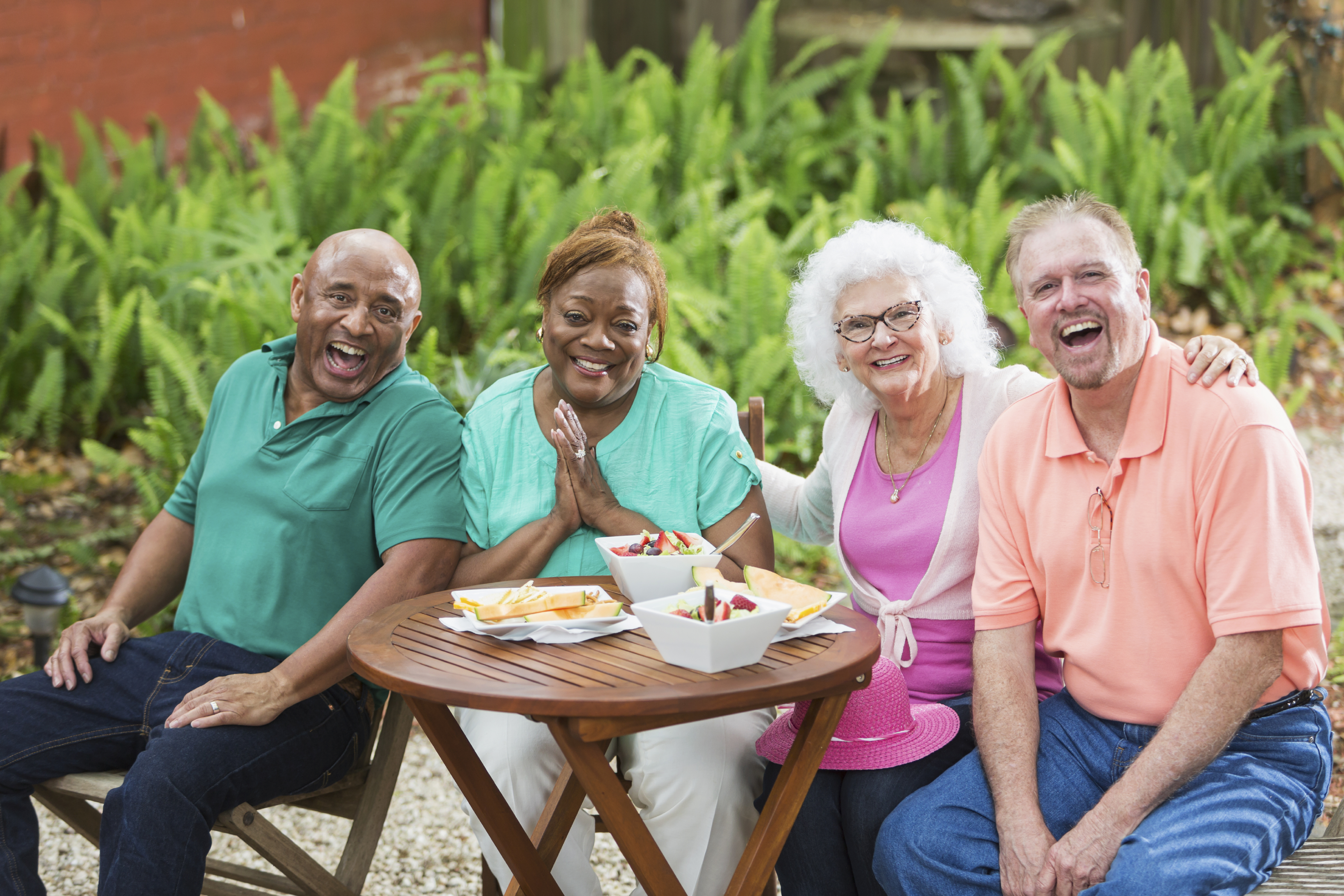 Group of seniors enjoying food and friends in back yard