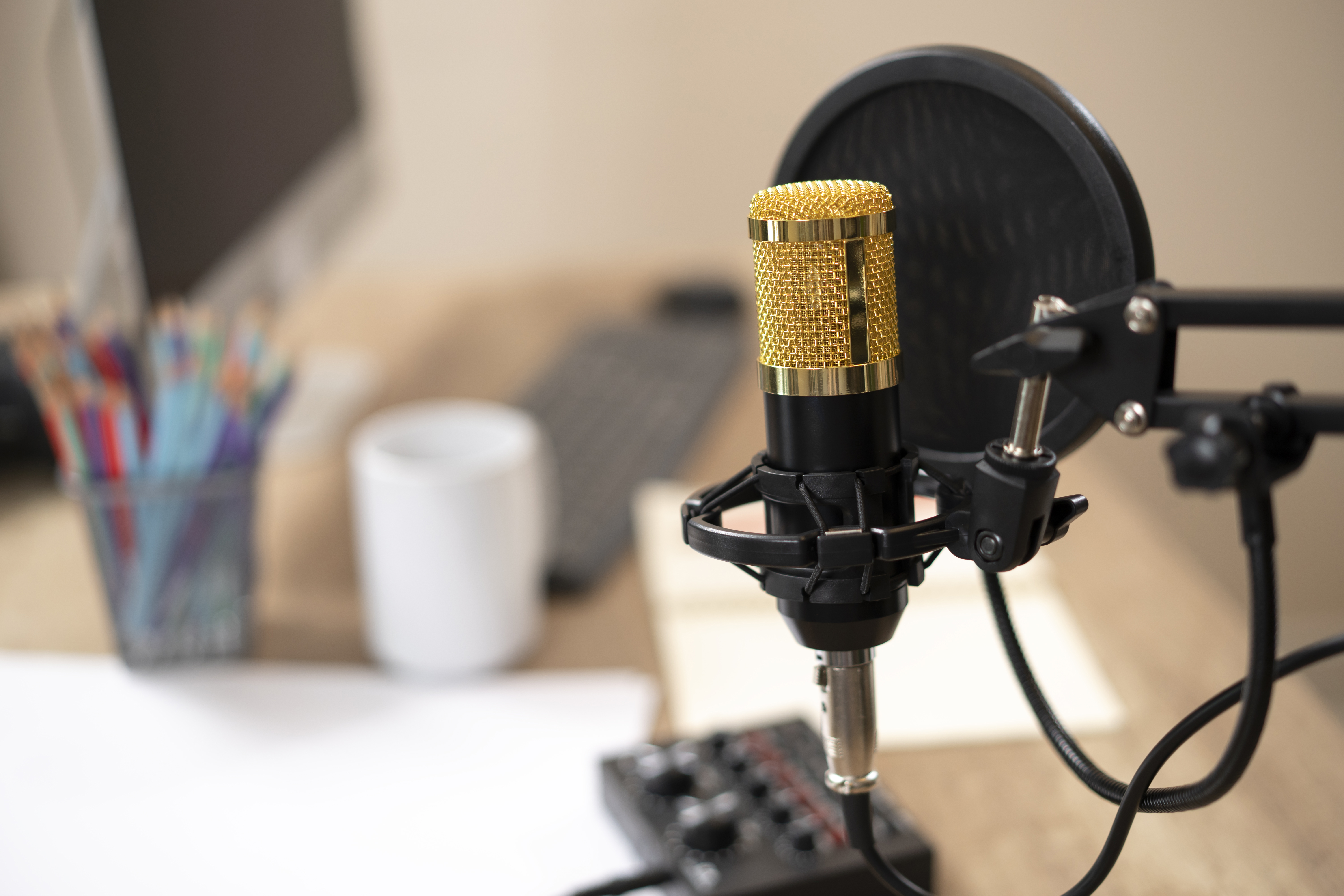 Studio podcast interior. Broadcast inside. Homemade room for podcaster. Voice microphone, laptop and lamp on the wooden table. Wide image