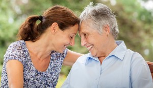 mother and daughter smile, face each other. family caregiving