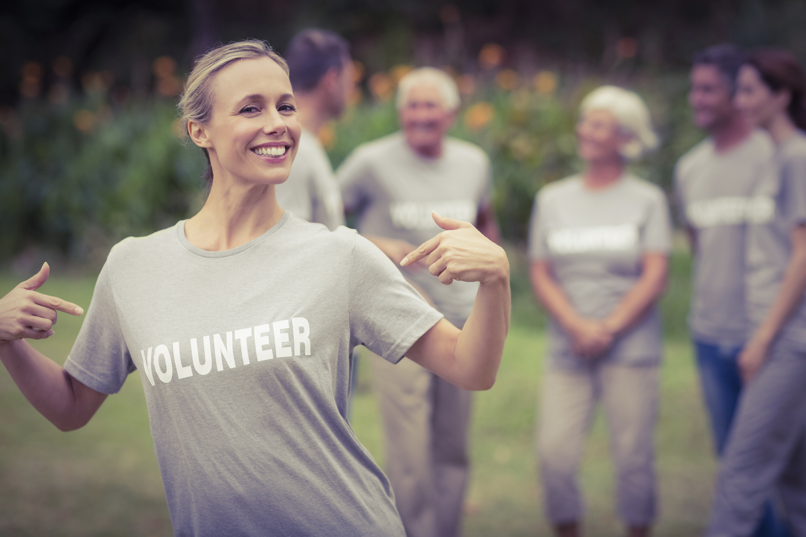 Happy volunteer showing her t-shirt to camera