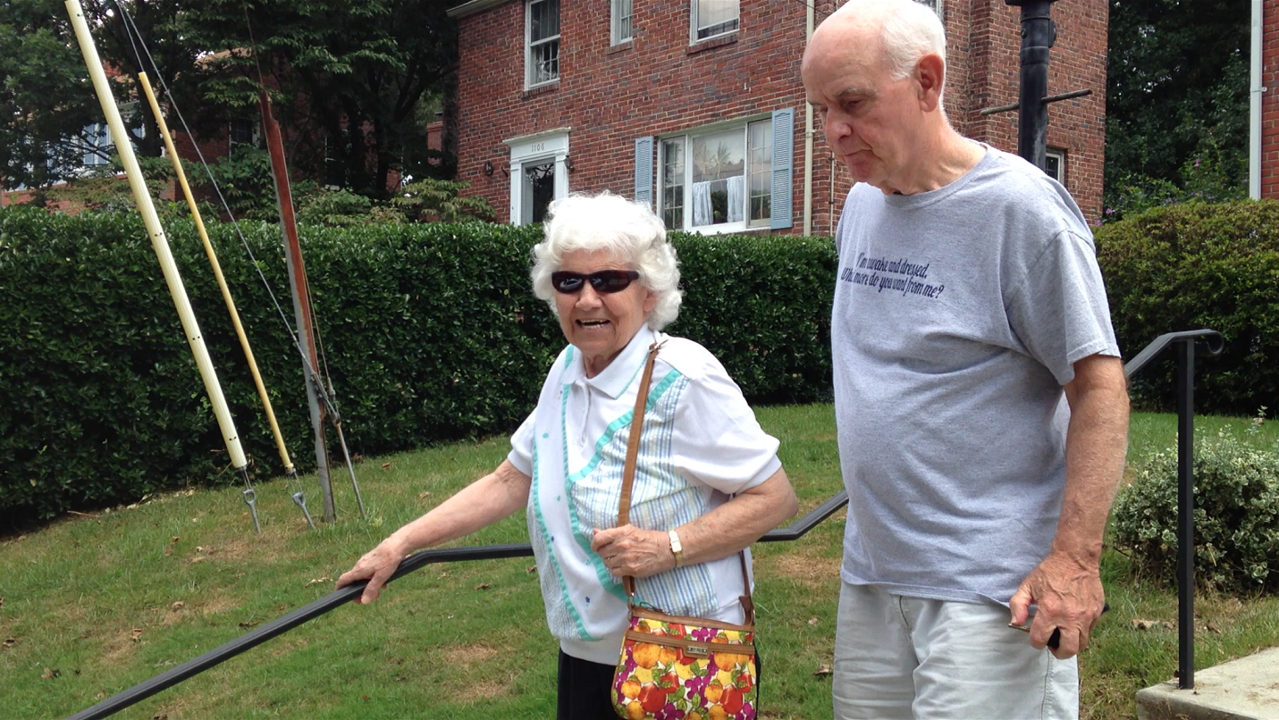 A volunteer escorts an elderly woman to his car to drive her to an appointment.