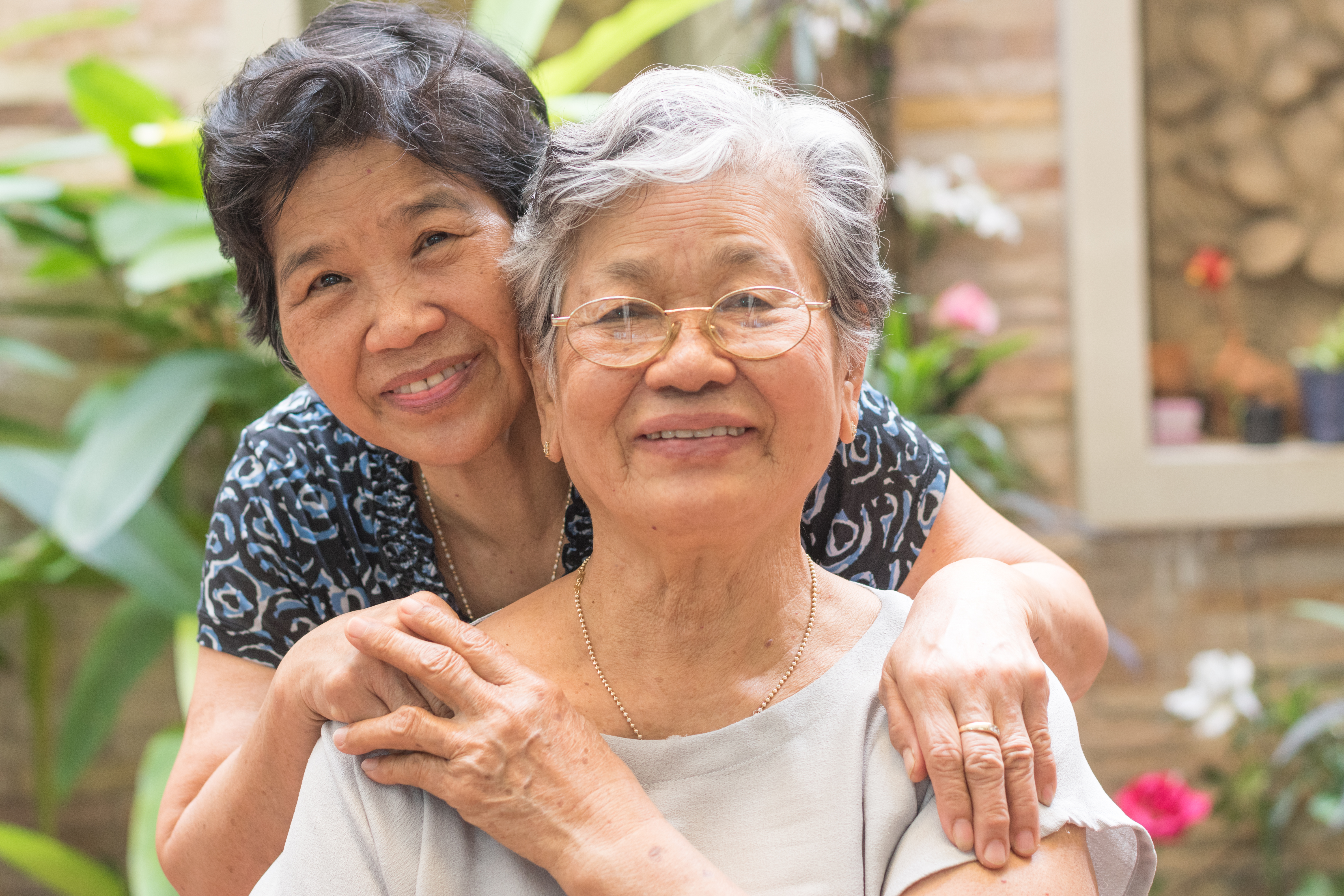 Happy senior friendship society concept. Portrait of Asian female older ageing women smiling with happiness in garden at home, nursing home, or wellbeing county