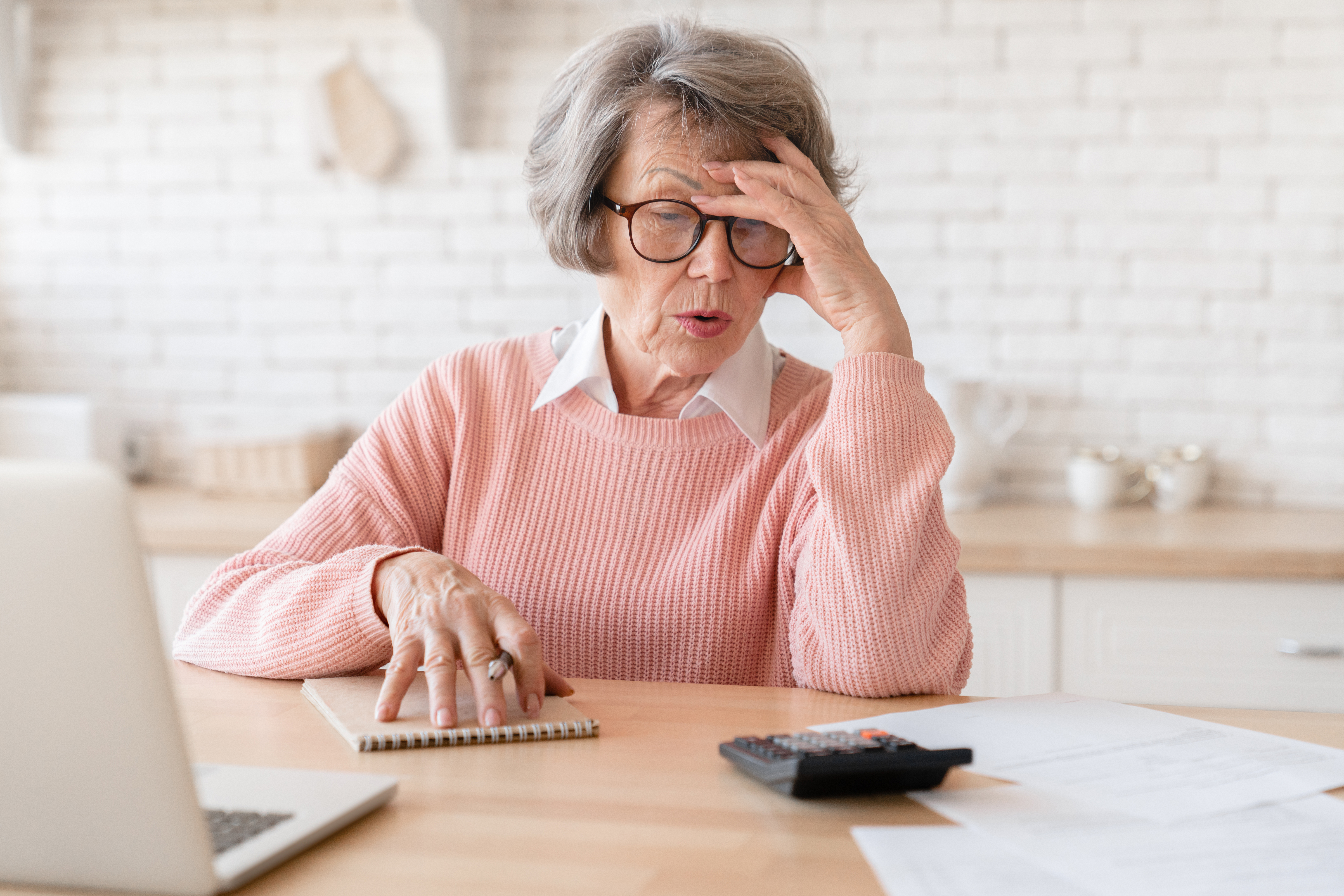 Stressed grandmother in debt, losing money, failing in calculation, domestic bills