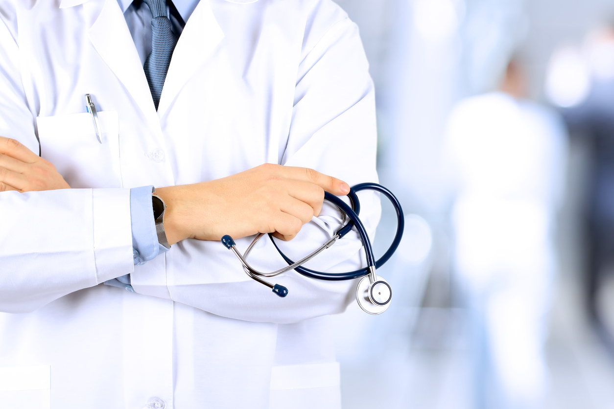 Portrait an unknown male doctor holding a stethoscope behind