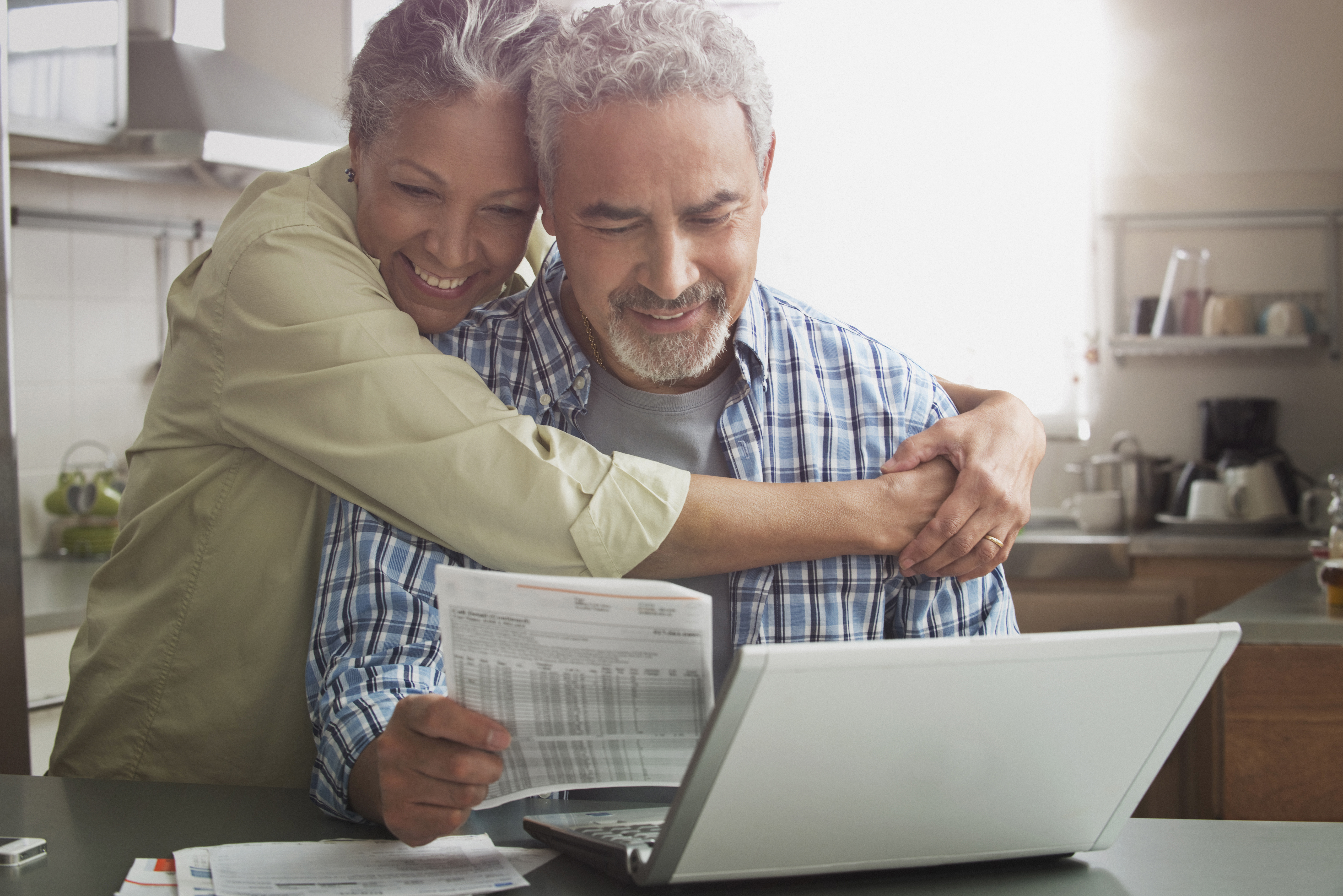 Hispanic couple paying bills on laptop