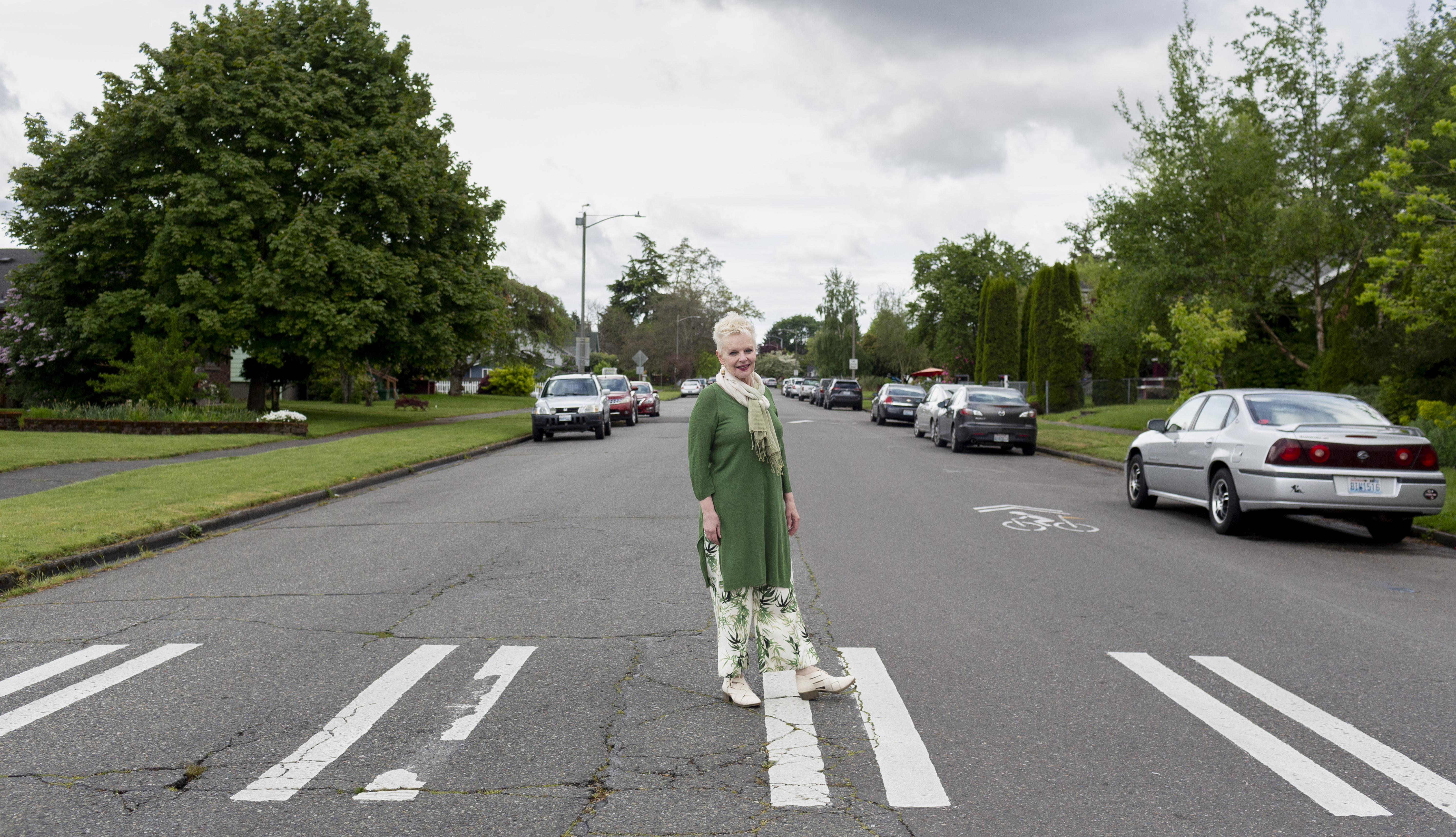 An older woman stands in a crosswalk