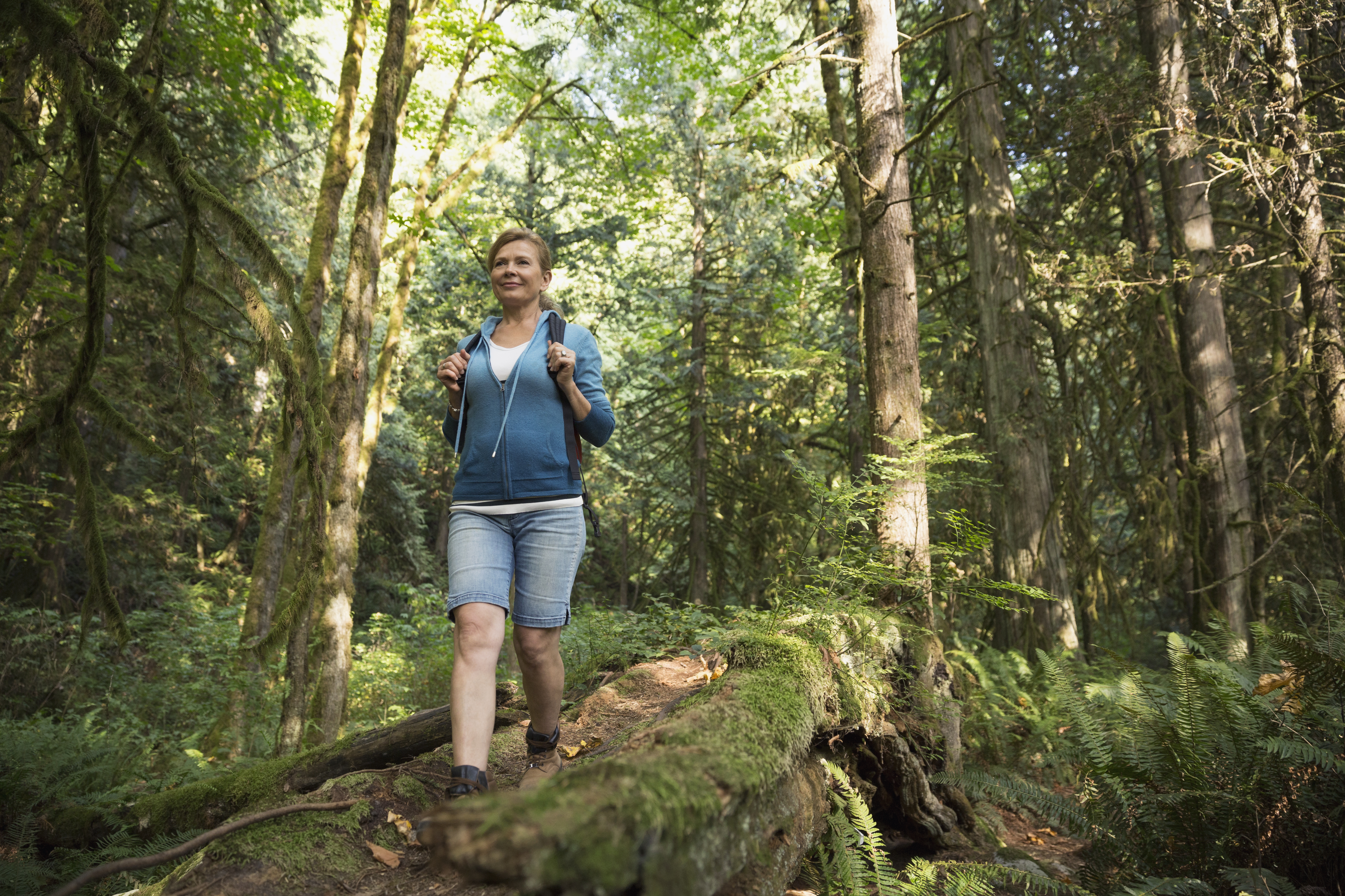 Woman descending hiking trail in woods