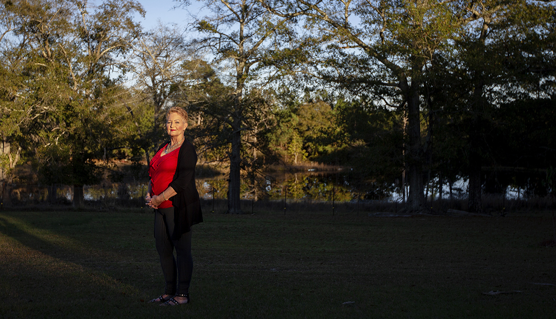 A woman stands in her backyard