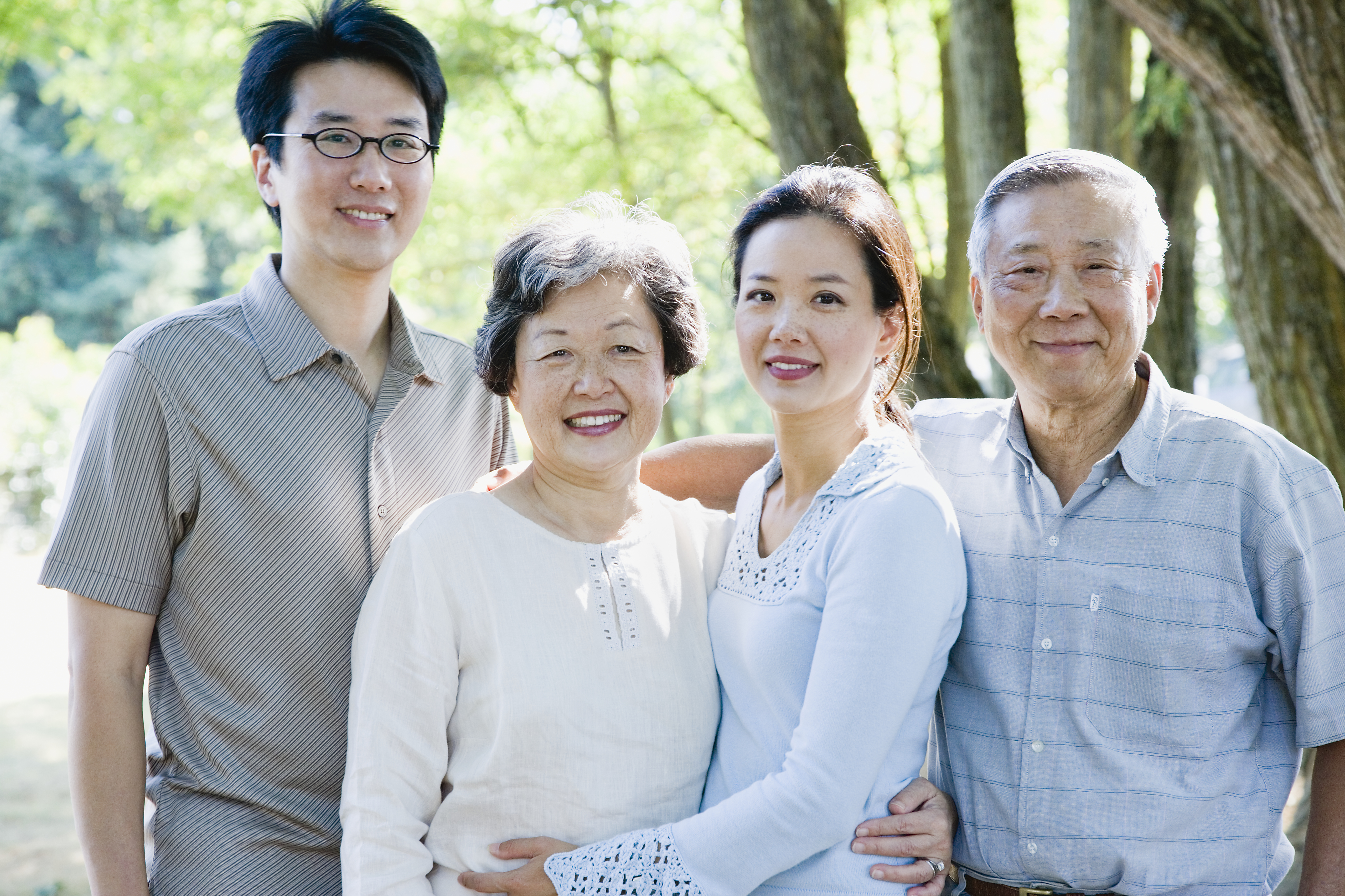 Senior couple standing with adult daughter and son-in-law, smiling, portrait