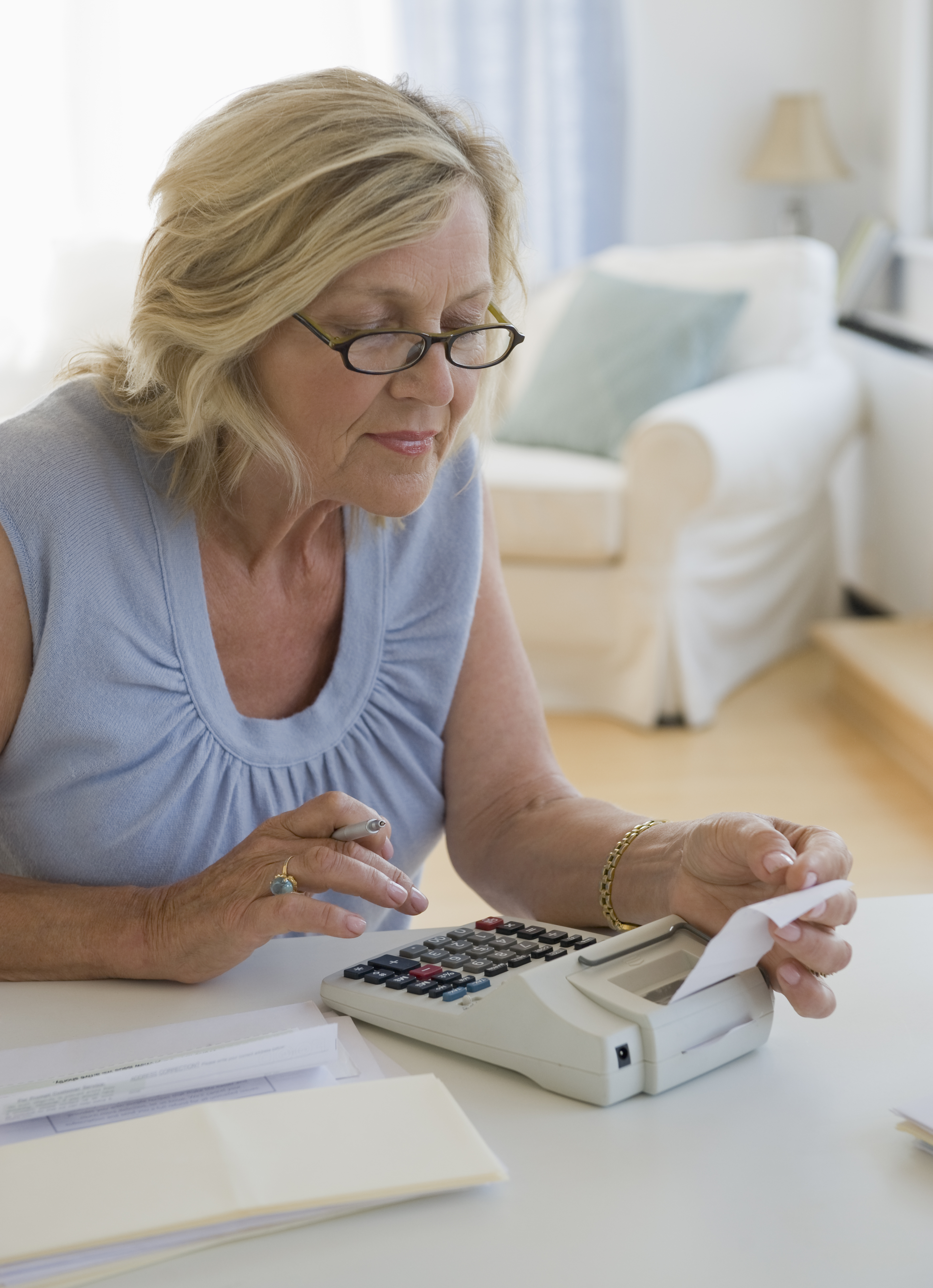 Woman using adding machine at home