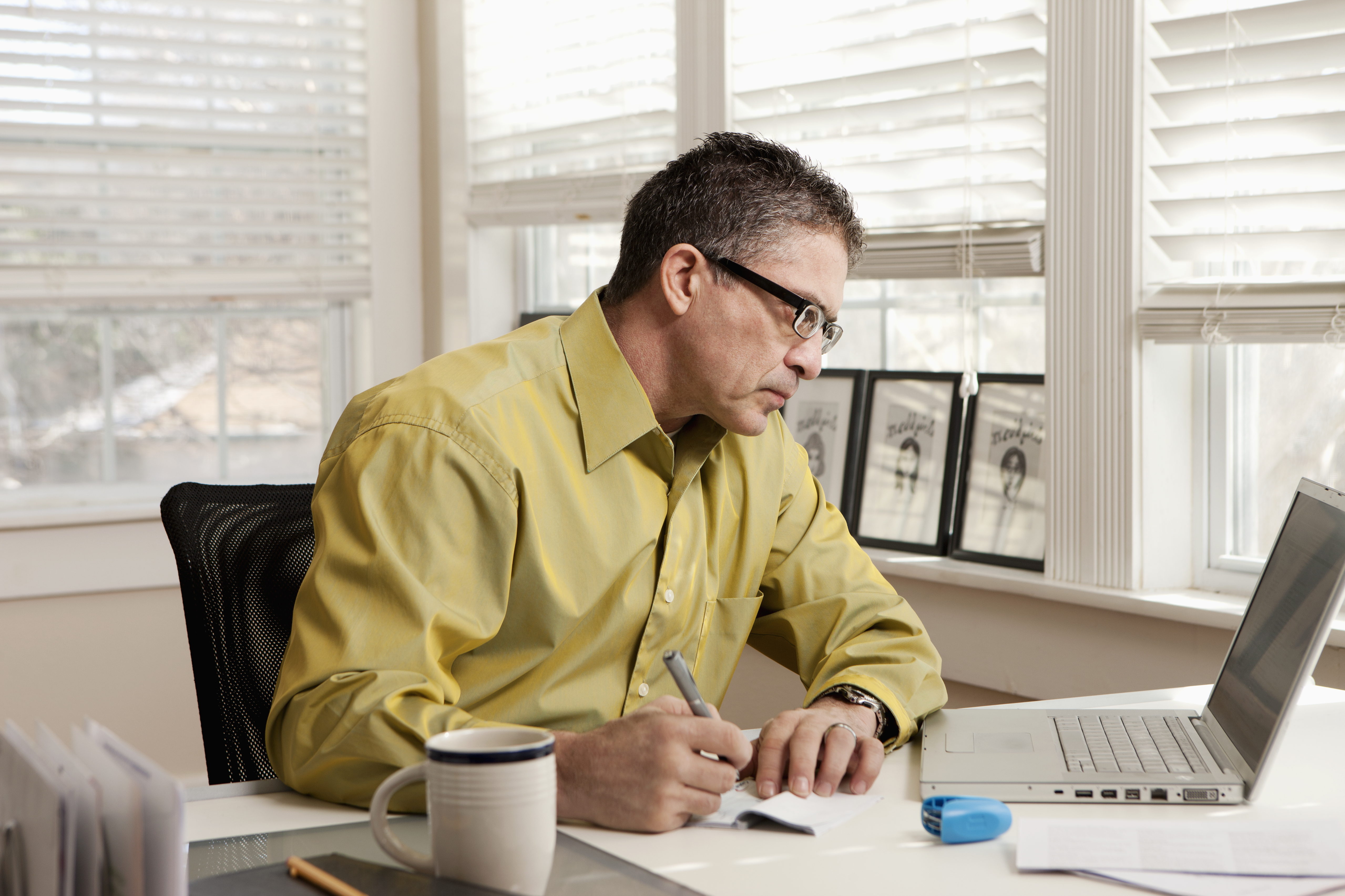 Hispanic man paying bills at desk