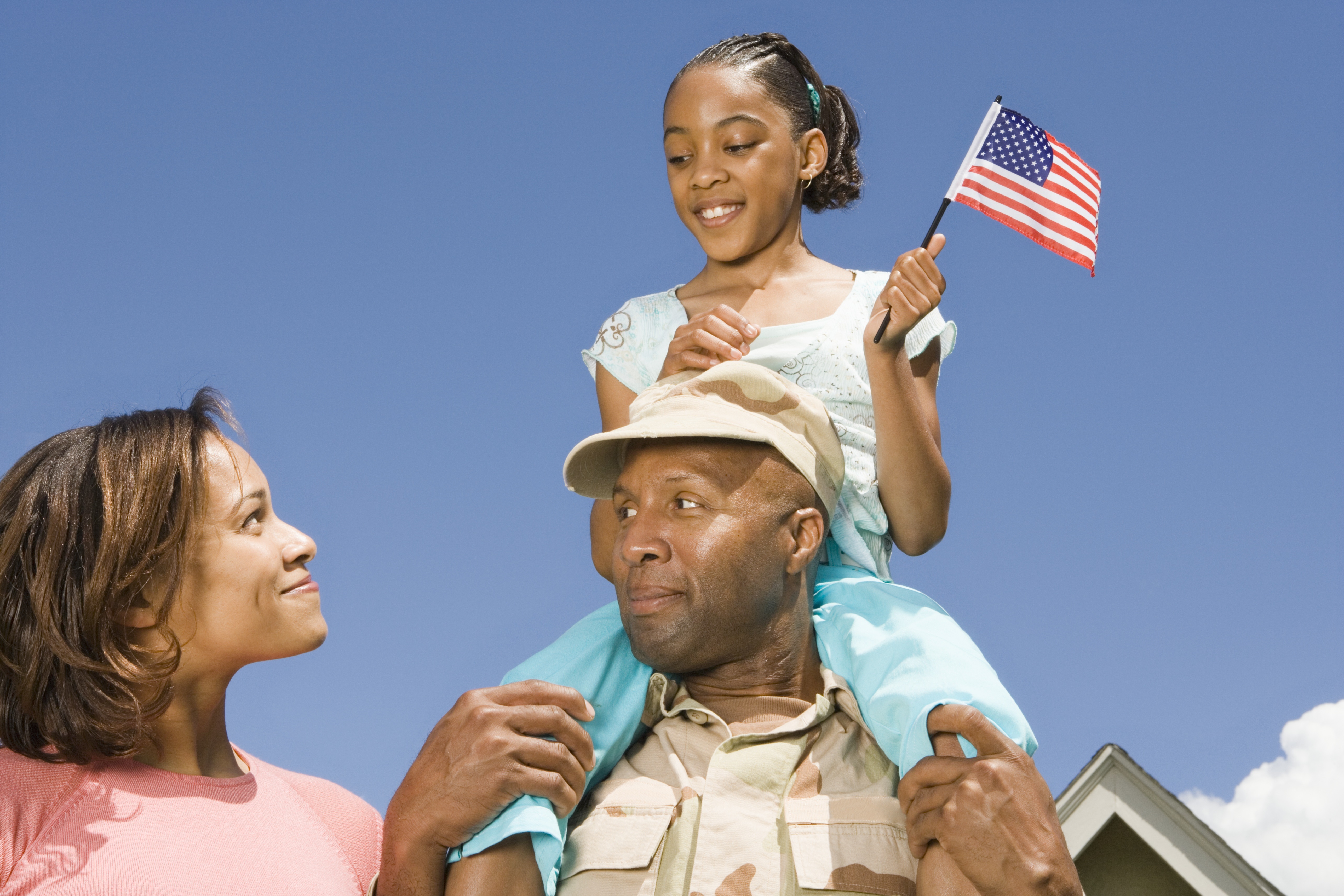 Military soldier holding daughter on his shoulders