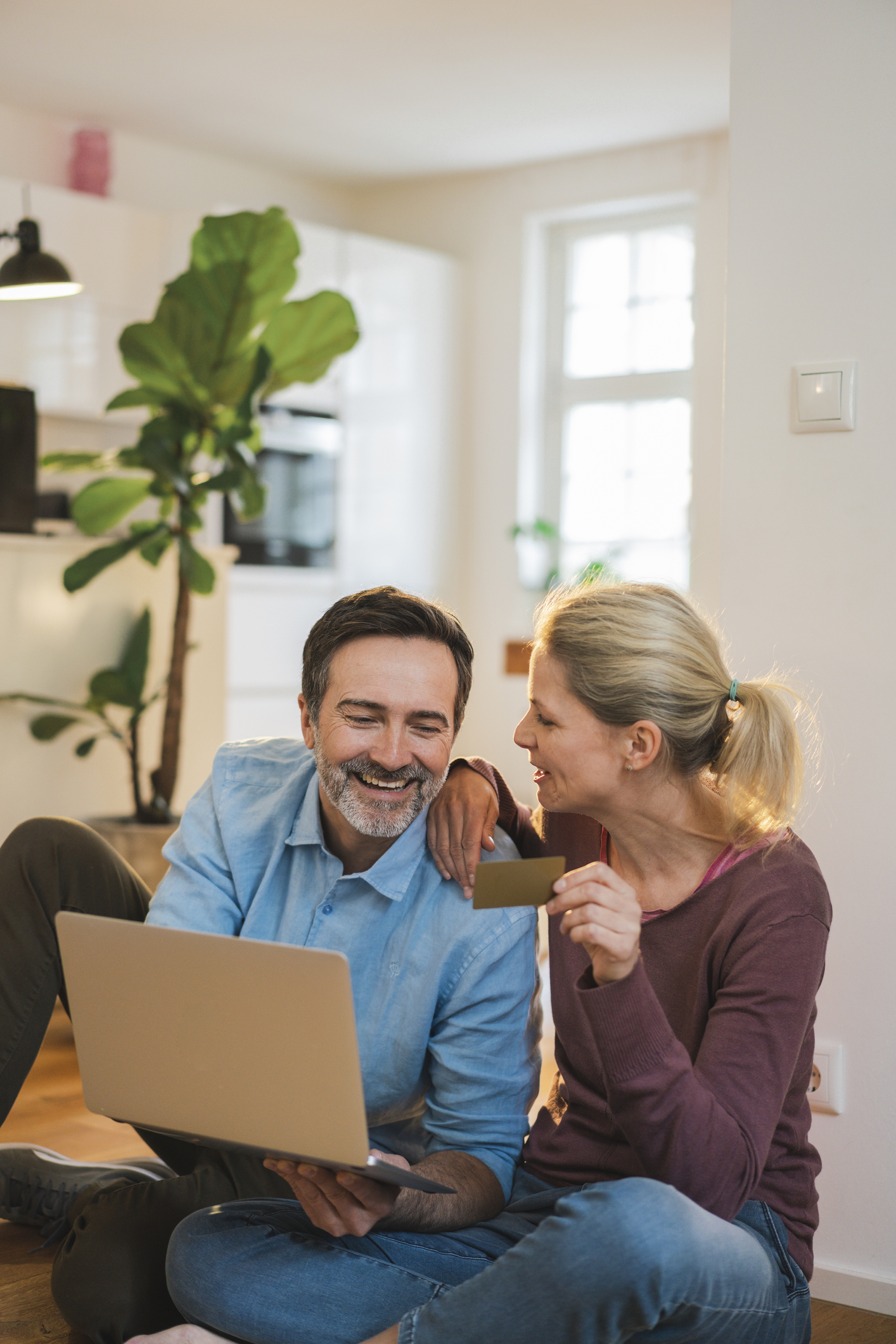 Happy couple enjoying doing online shopping at home