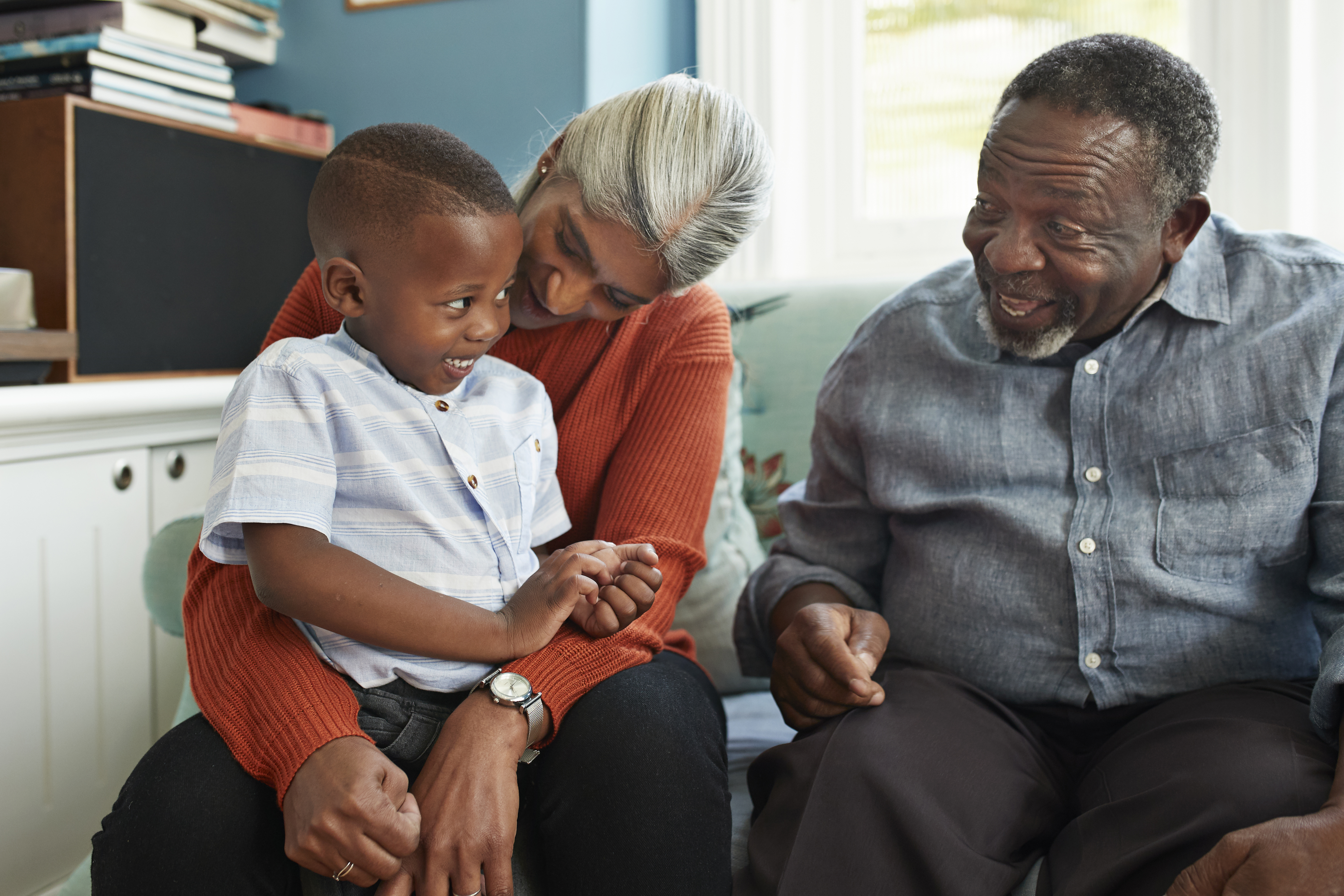 Happy man talking with cute boy standing at home