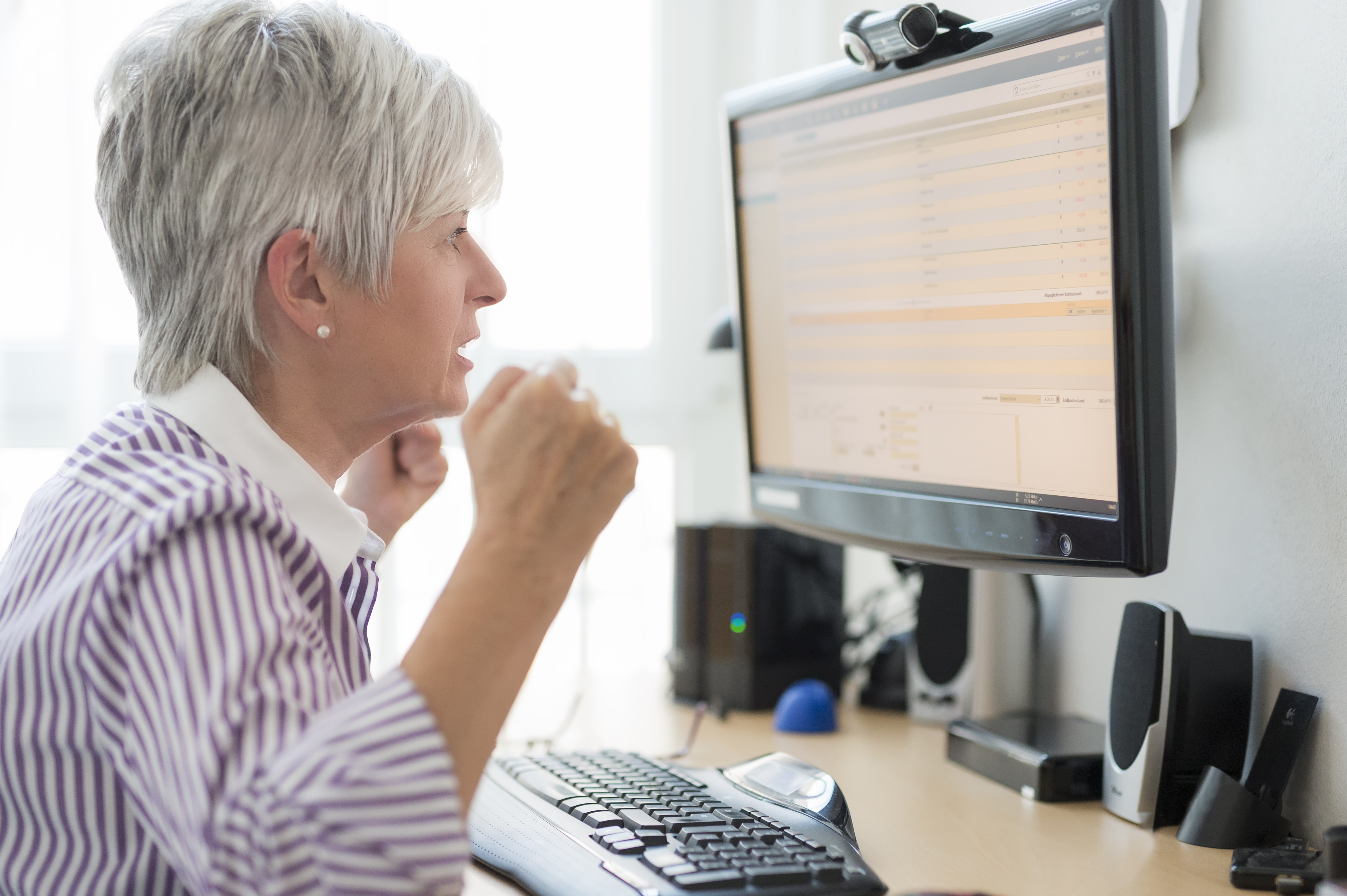 Senior woman looking horrified at computer monitor