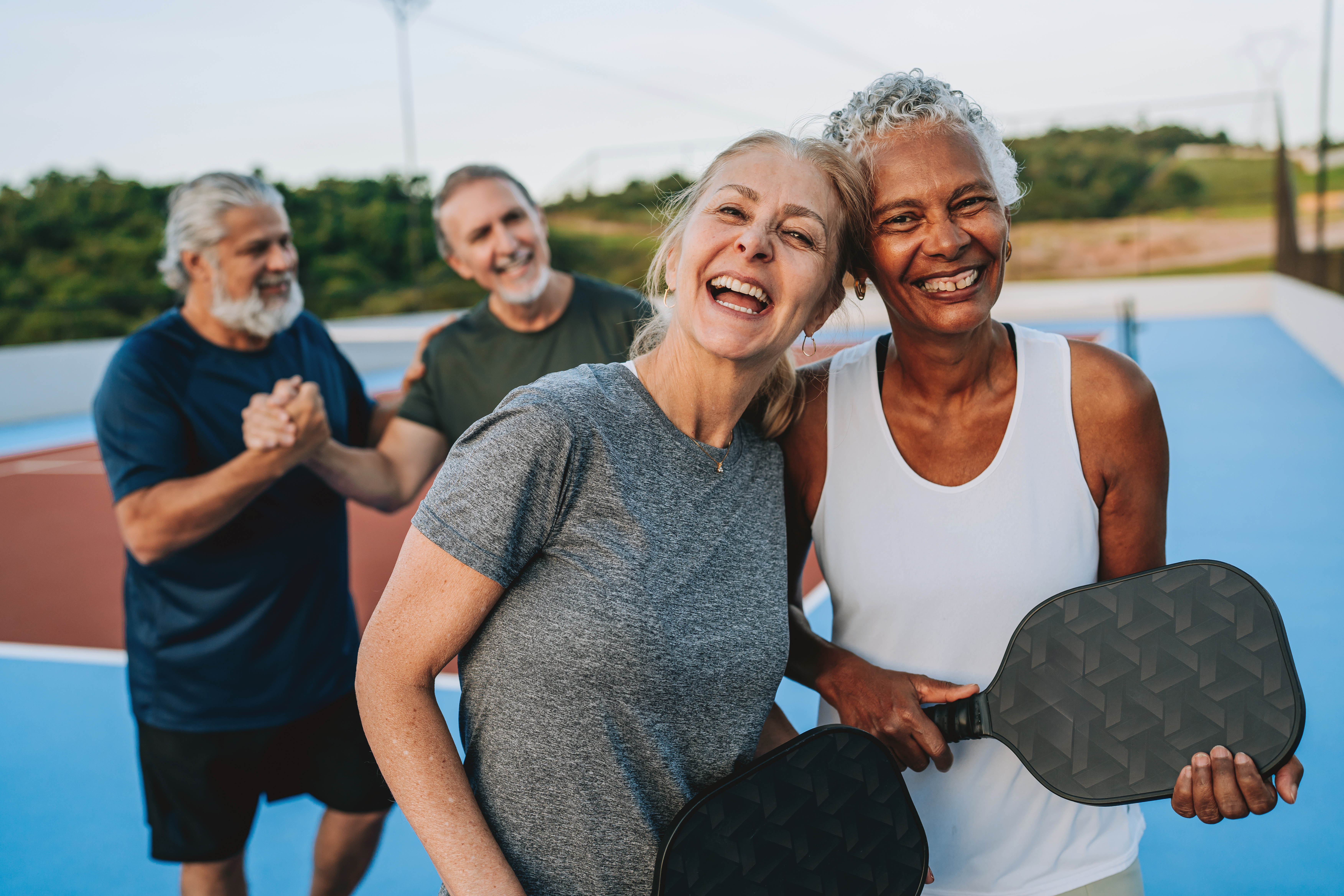 Group of people playing pickleball looking at camera