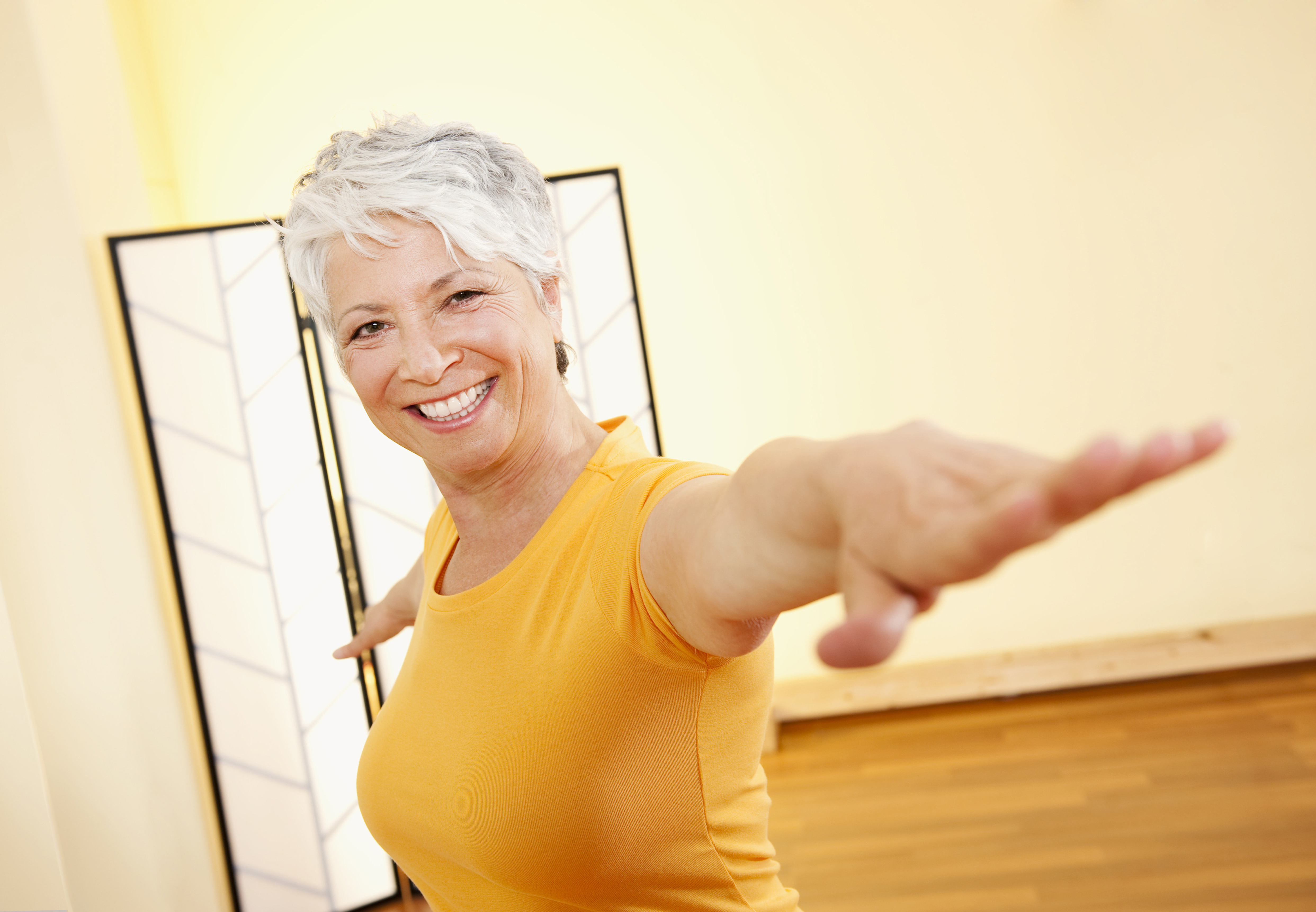 Senior woman with outstretched arms, smiling, portrait