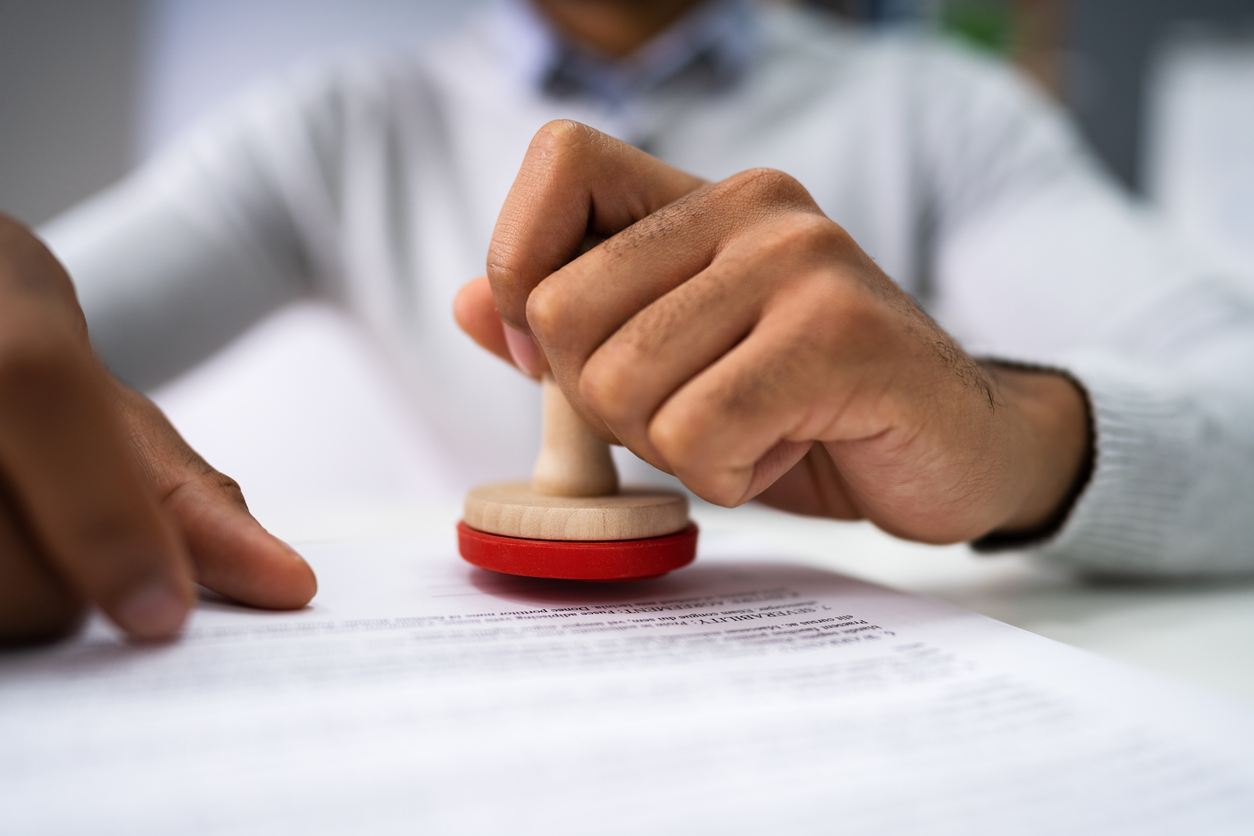 Person Hands Using Stamper On Document