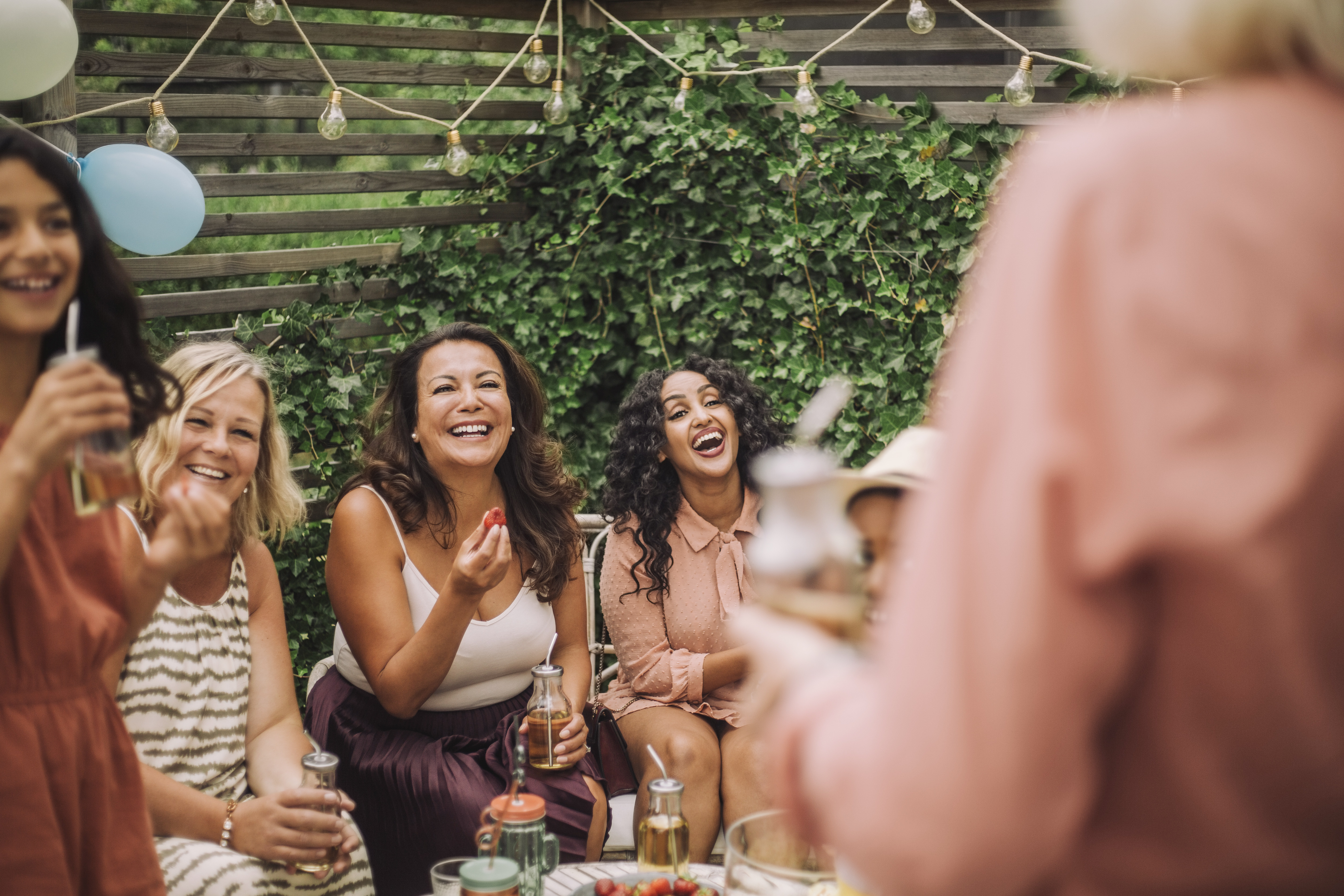 Cheerful family having food during birthday party in backyard