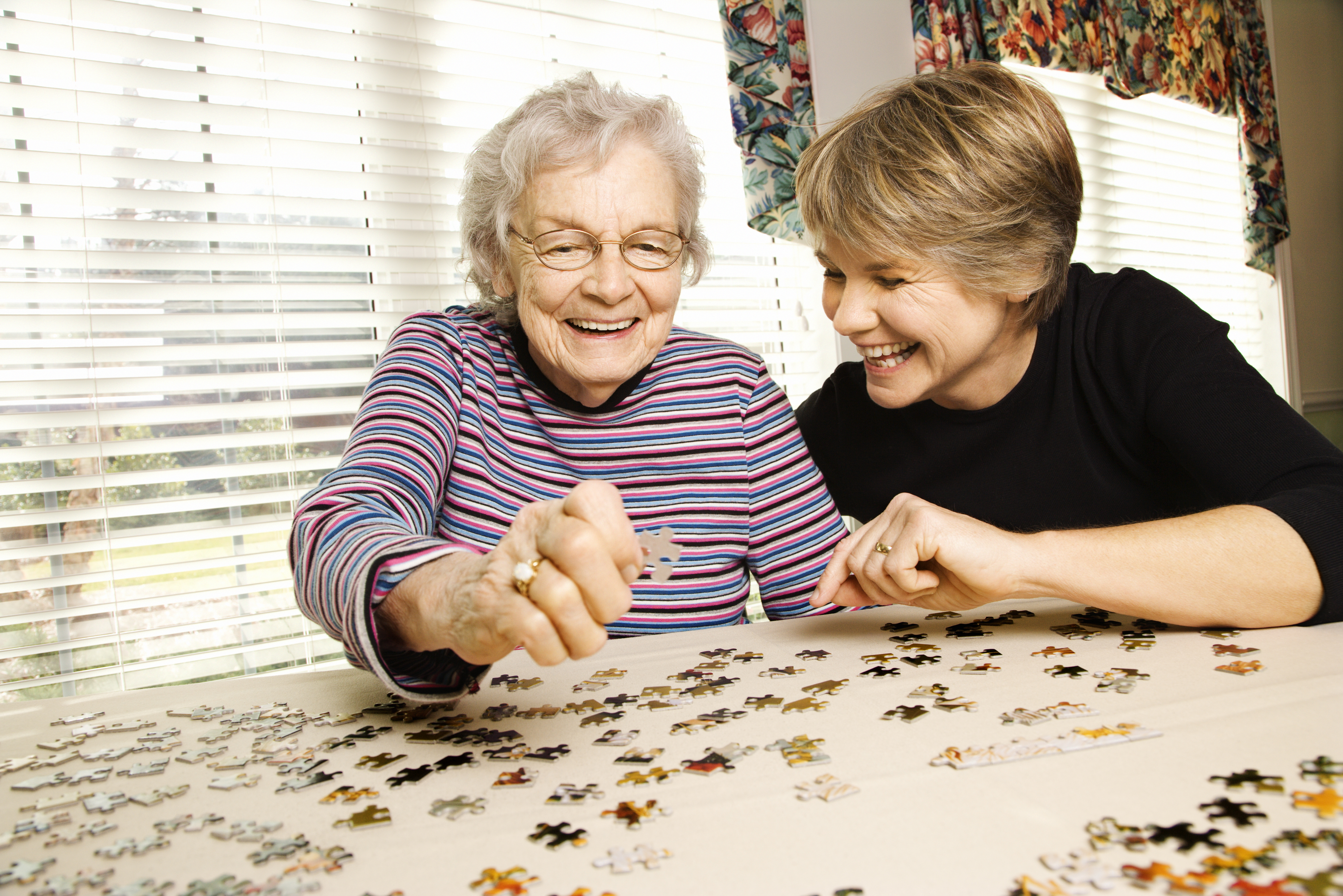 Elderly Woman and Younger Woman Doing a Puzzle