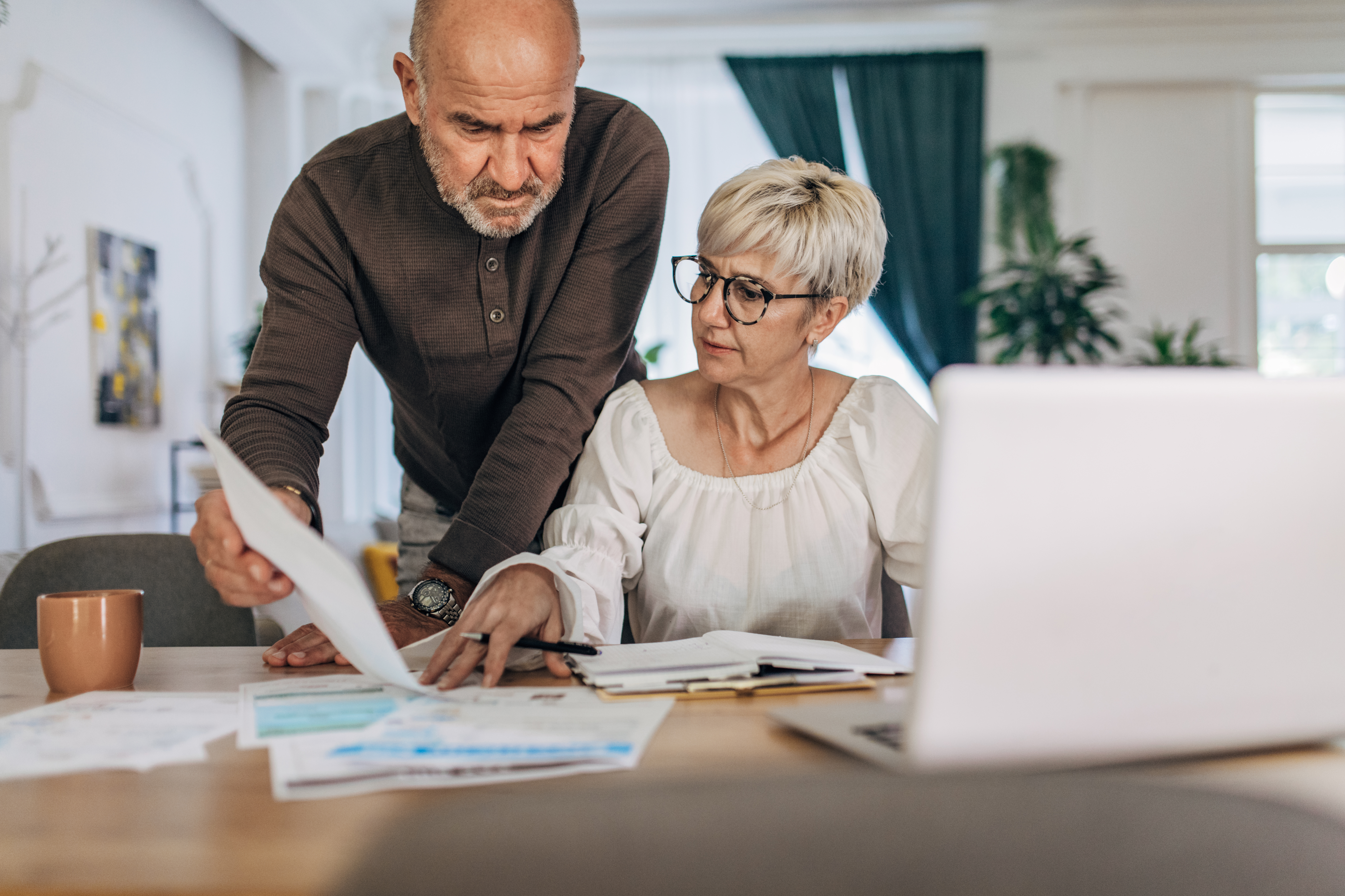 Couple calculating bills and taxes and home and trying to organise to pay them