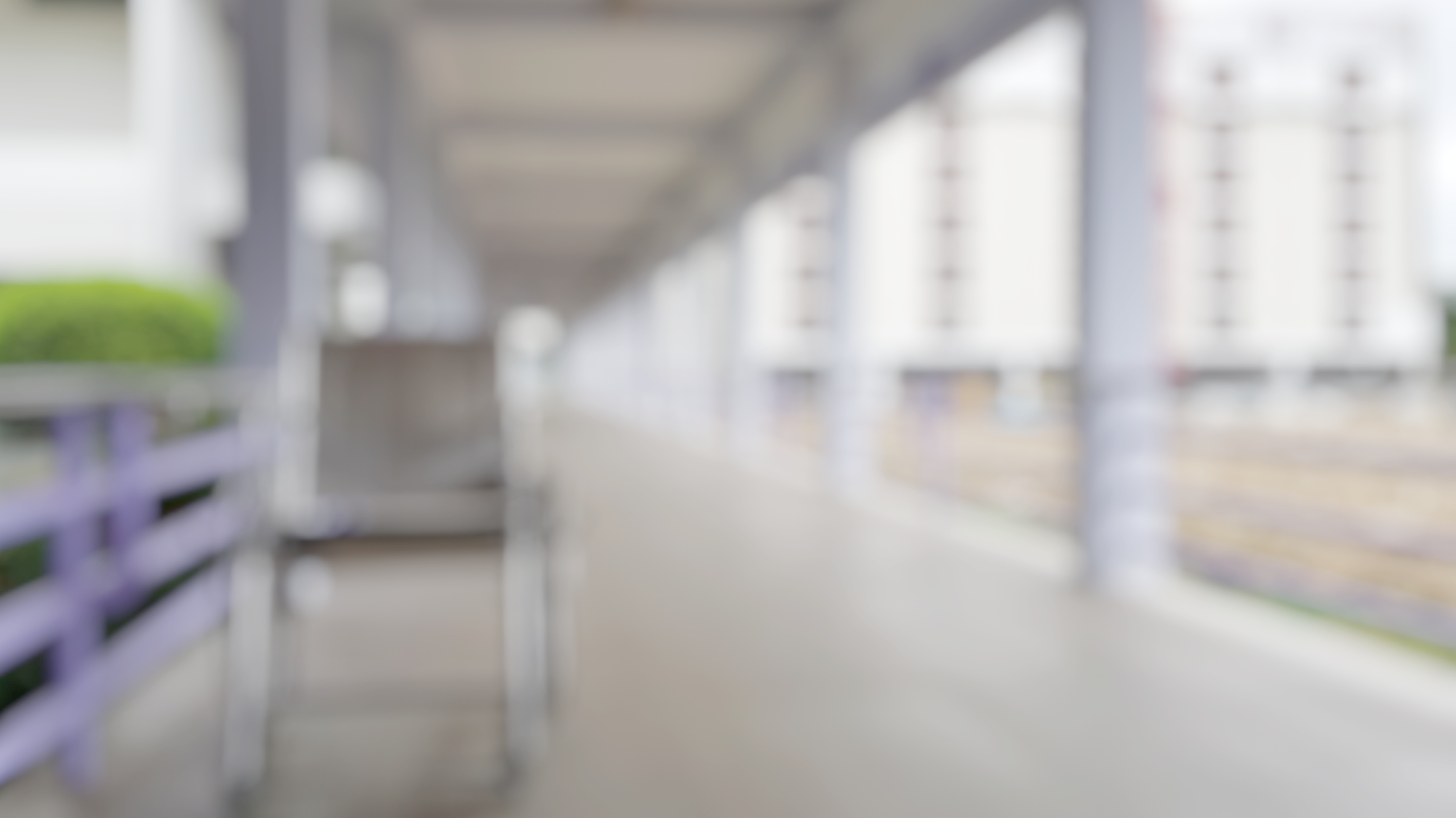 Blur abstract background of corridor in clean hospital with patient wheelchair in hospital. Blurry wheel chair for World Disability Day.   Defocus lobby and waiting area.