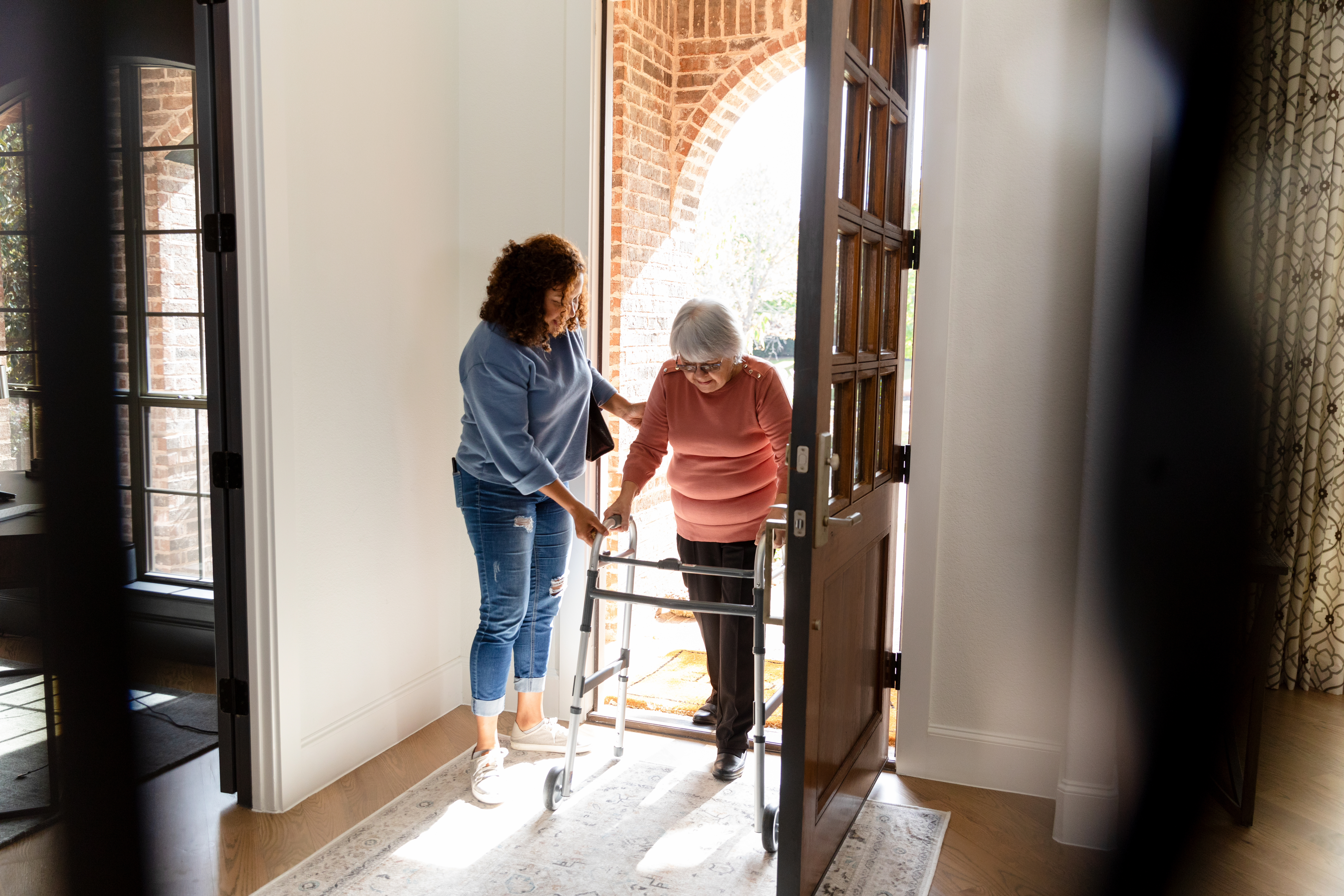 Woman Assisting Senior Woman with Walker