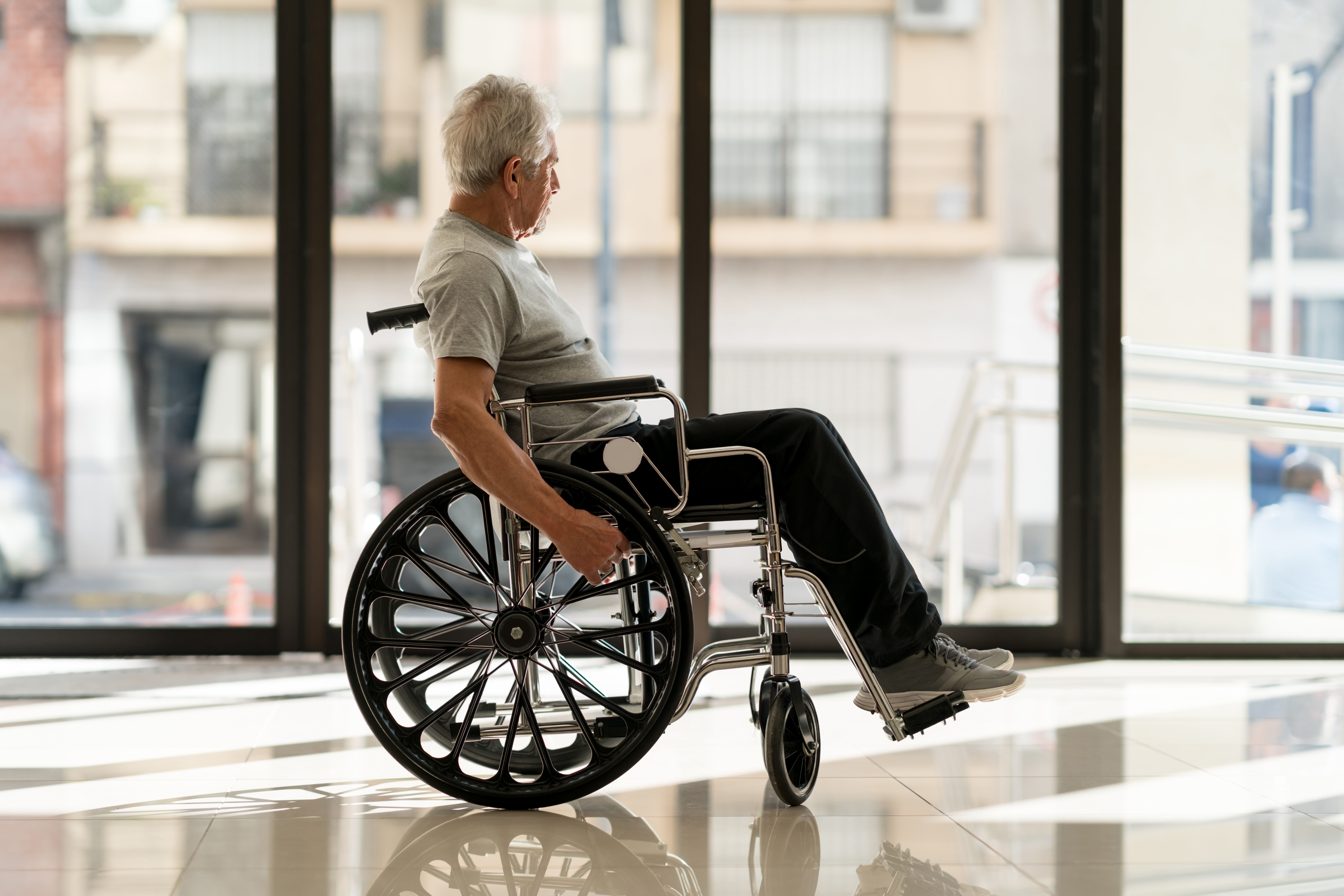 Disabled senior man at a nursing home looking away to the door