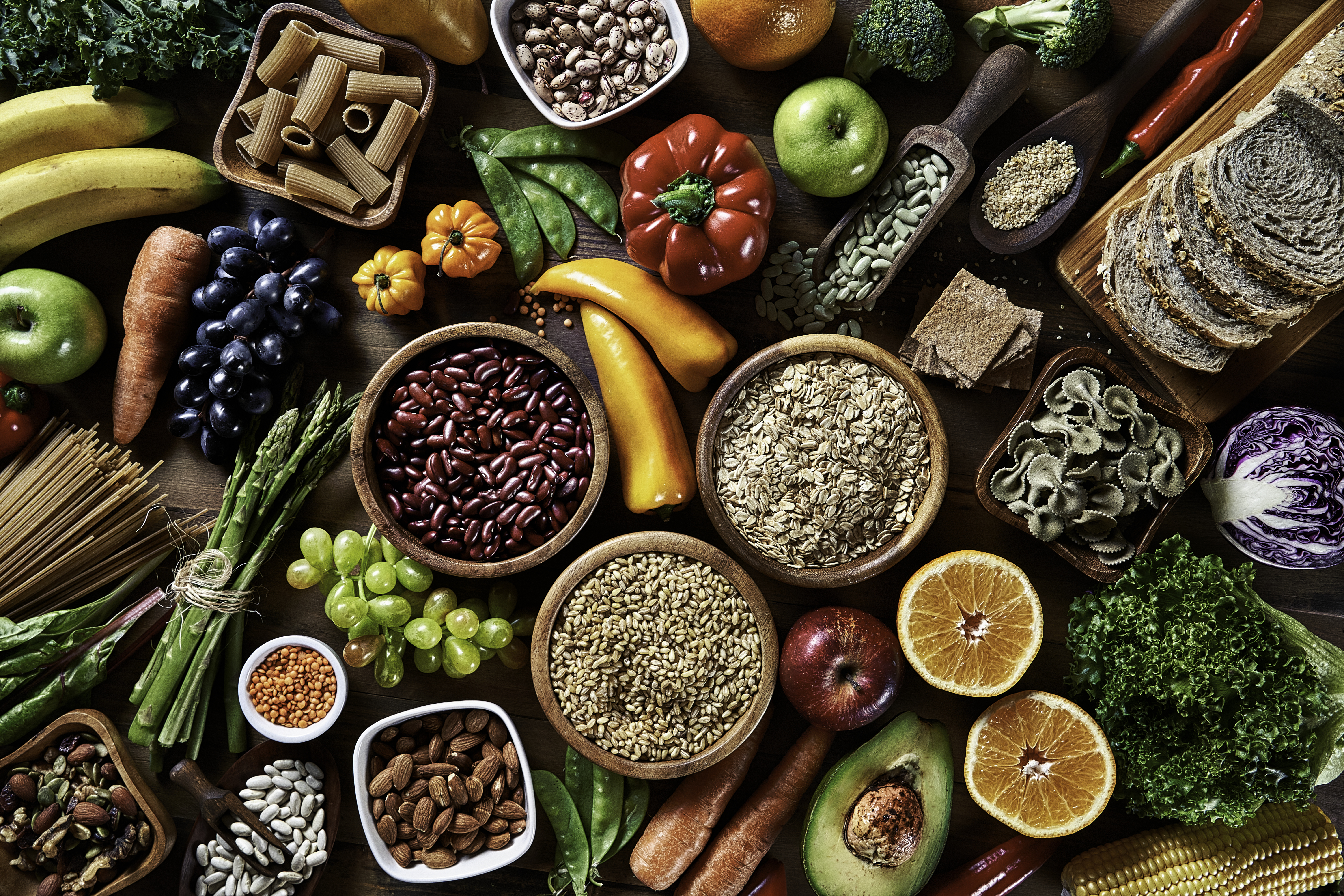 Top view of dietary fiber fresh vegan food and legumes on rustic wooden table. Healthy food themes.
