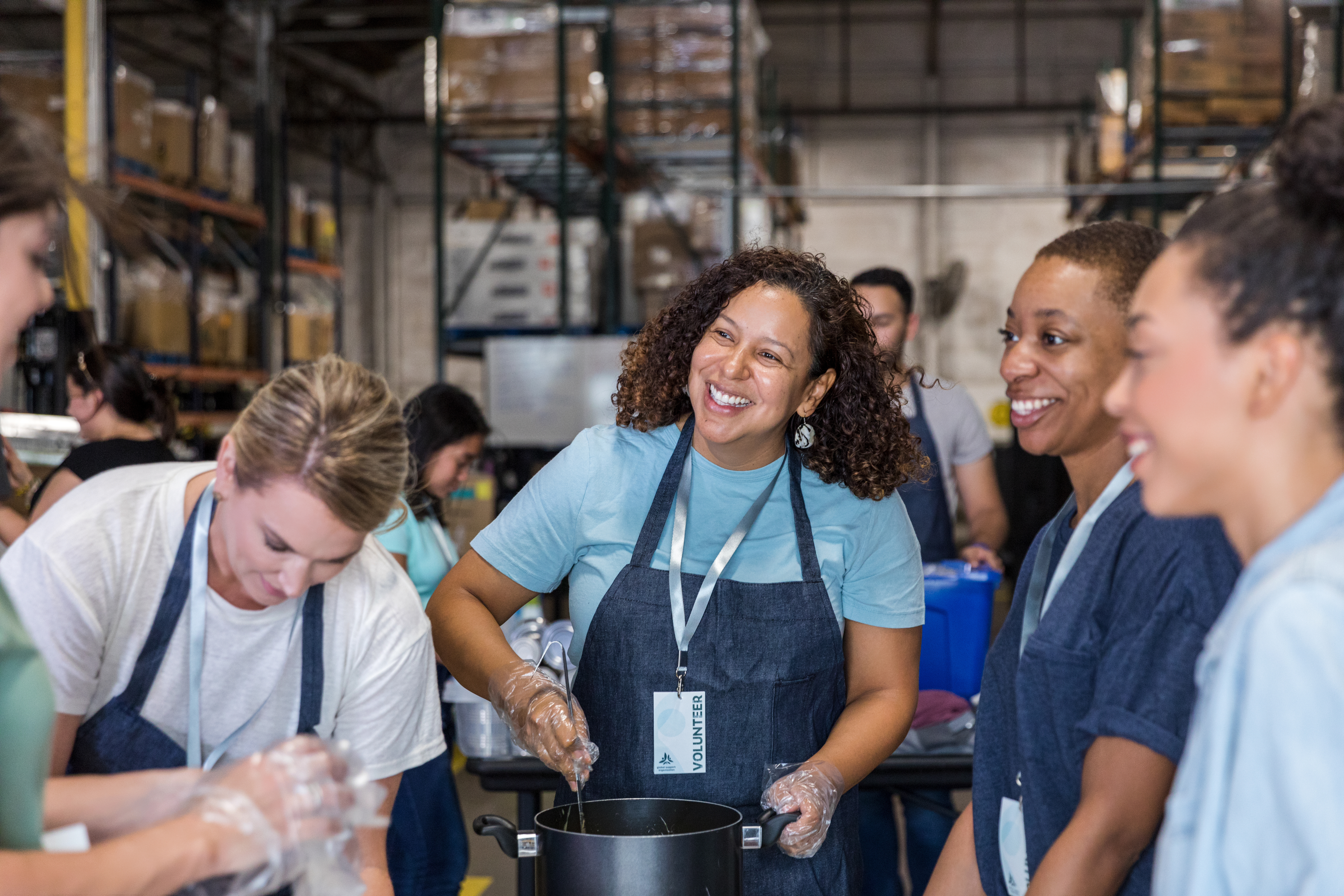 Women smile and talk while preparing food for soup kitchen