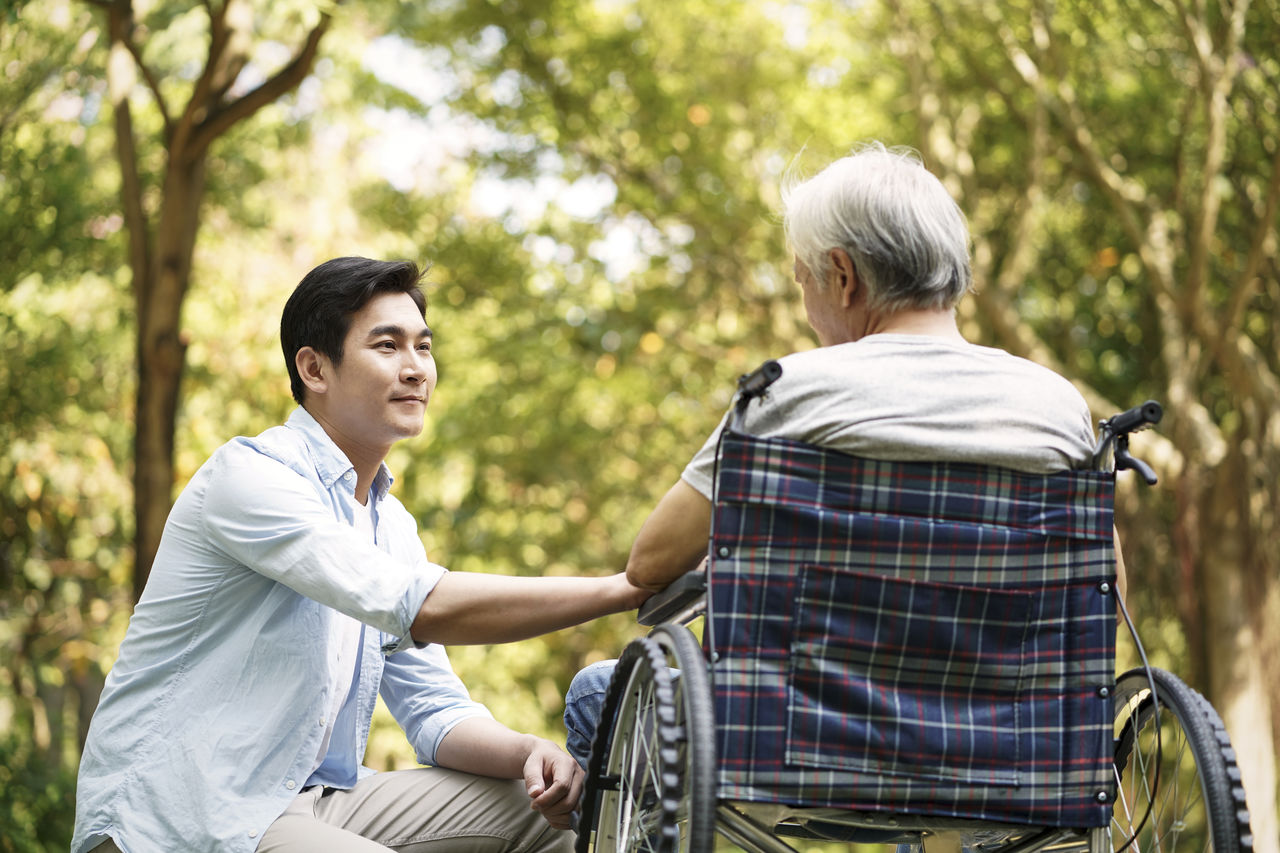 asian son comforting wheelchair bound father image .jpg