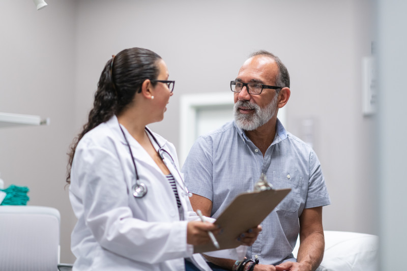 Female doctor in consultation with mature adult man