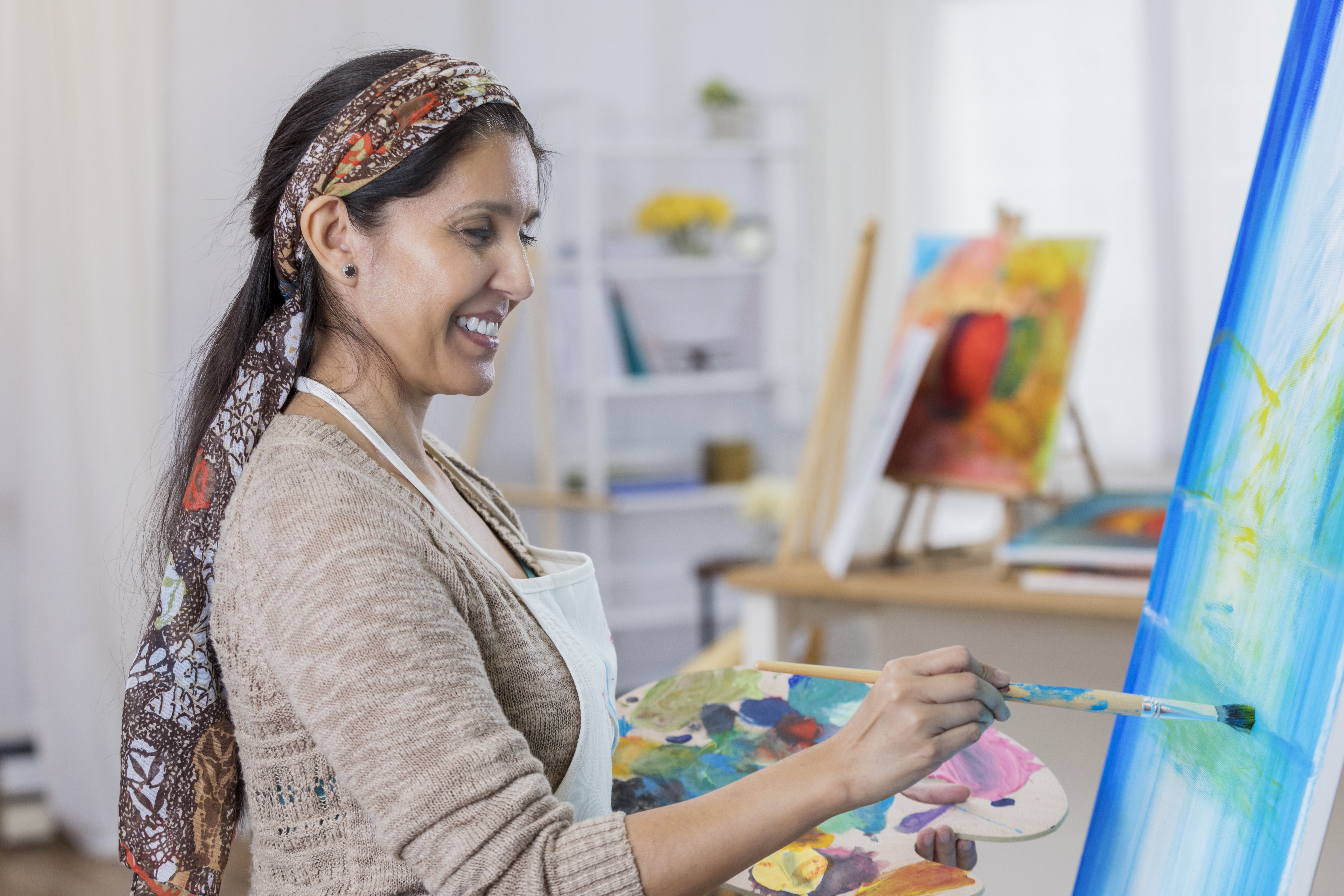 Beautiful woman paints in her art studio