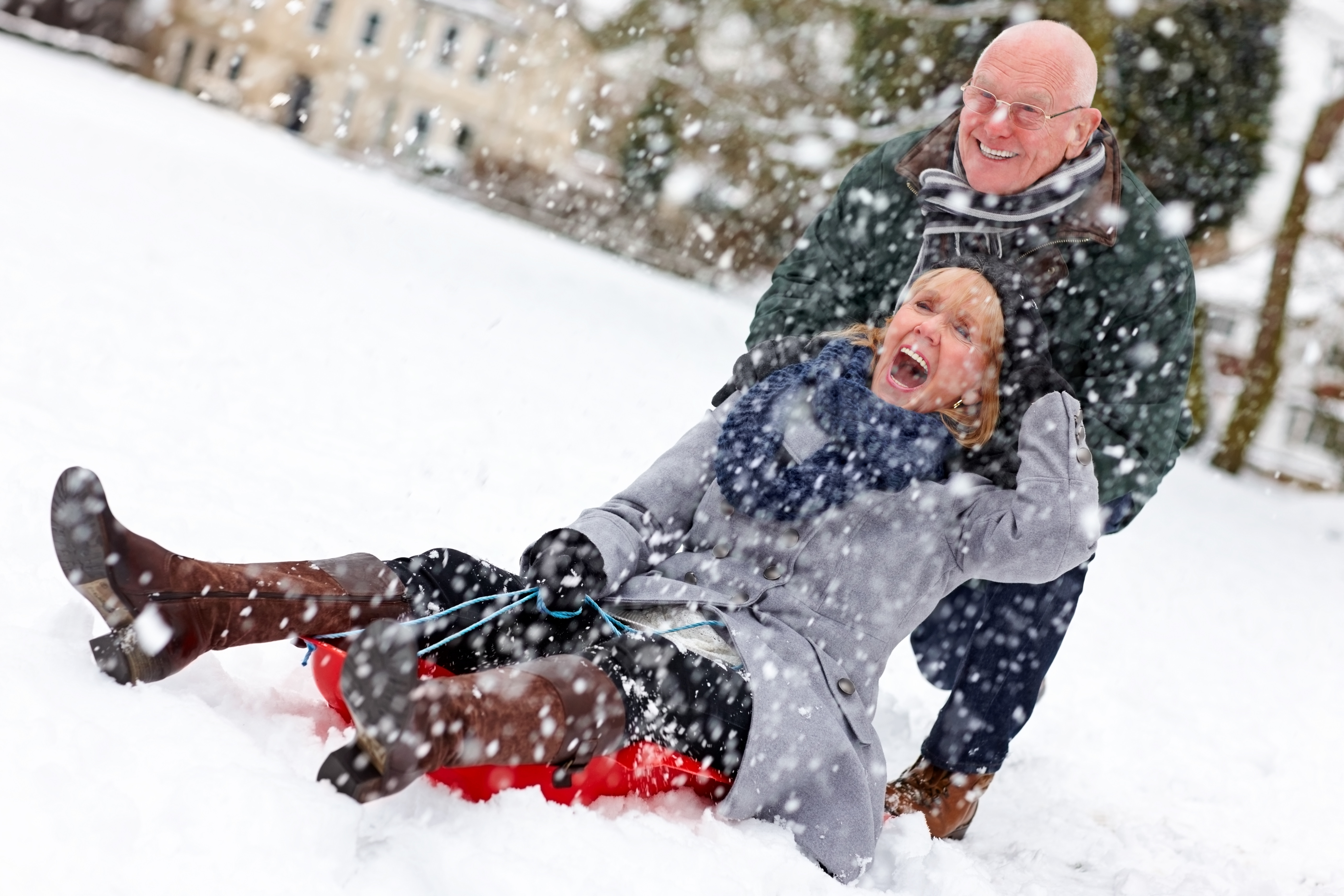 Senior couple on sled having fun